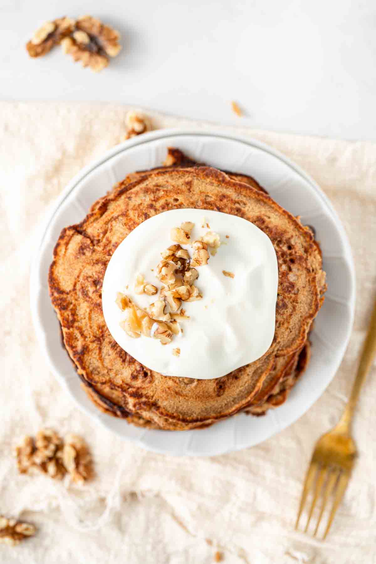 Overhead of pancakes with yoghurt and walnuts.