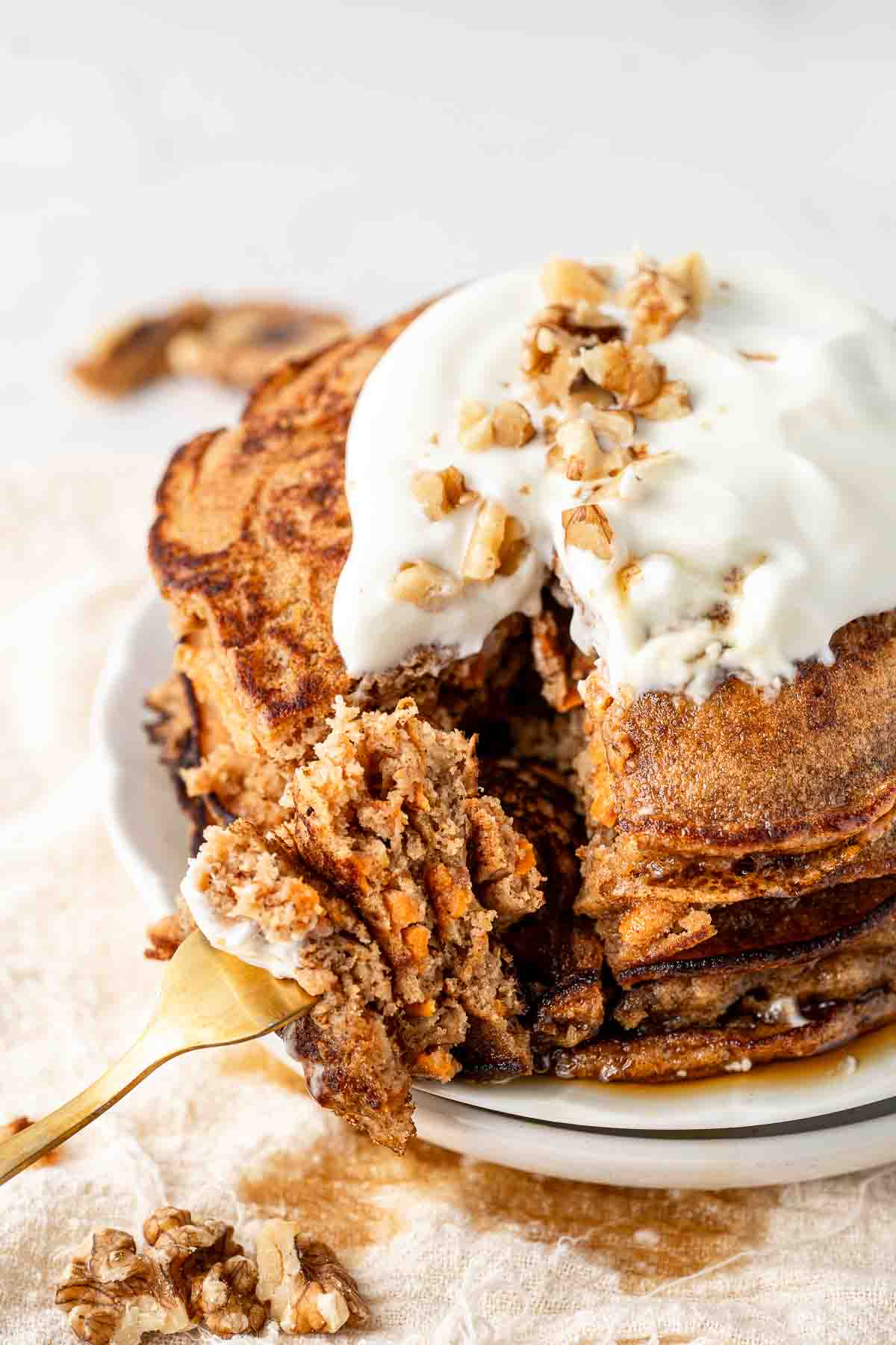 Close up of a bite of a stack of carrot cake pancakes.