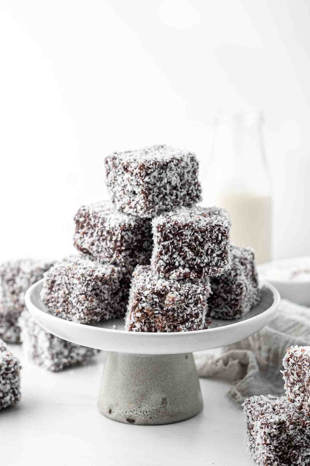 A stack of classic lamingtons on a cake stand.