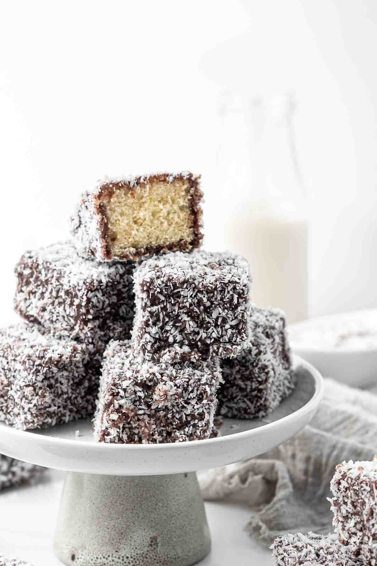 A stack of lamingtons on a cake stand. 