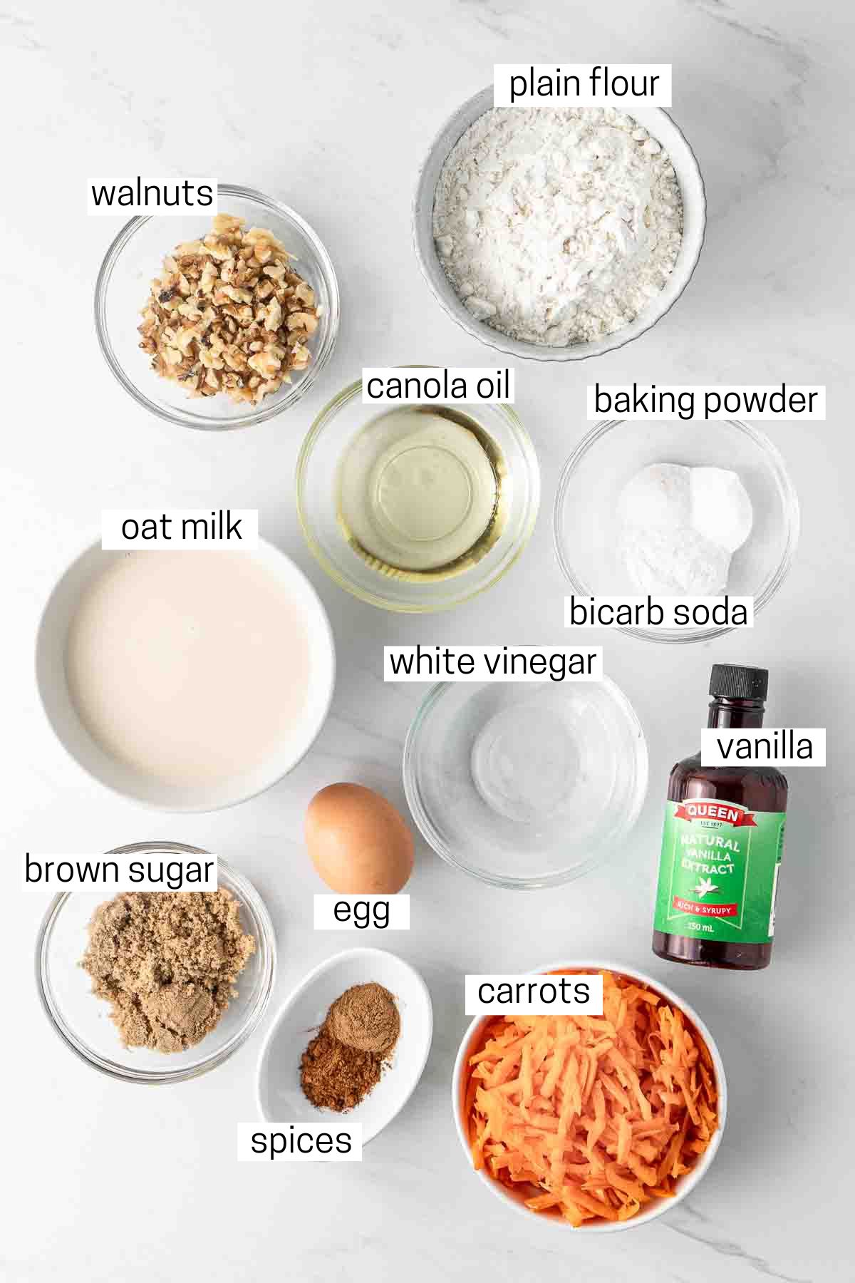 All ingredients needed for carrot cake pancakes laid out in small bowls.