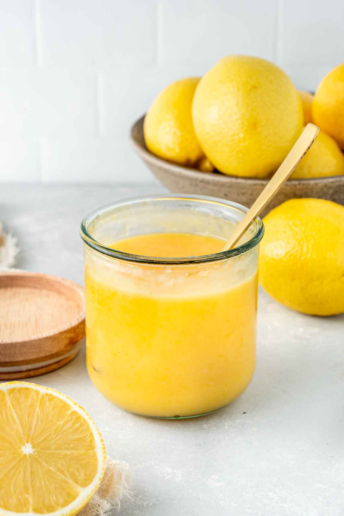 Dairy Free Lemon Curd in a glass jar with a spoon.