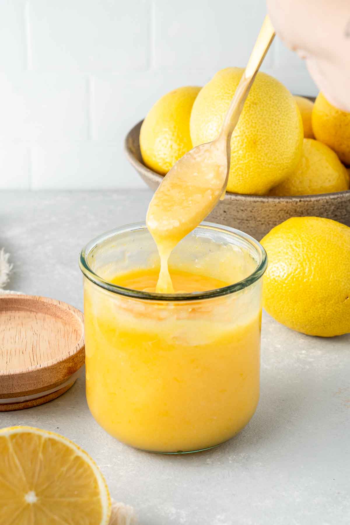 Dairy free lemon curd in a jar with a spoon.