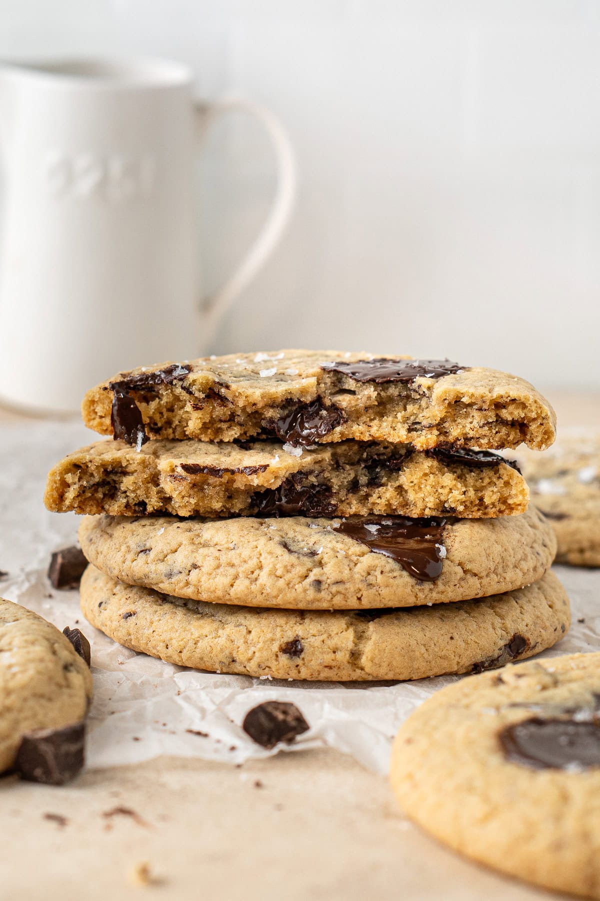 A stack of chocolate chip cookies, one broken in half.
