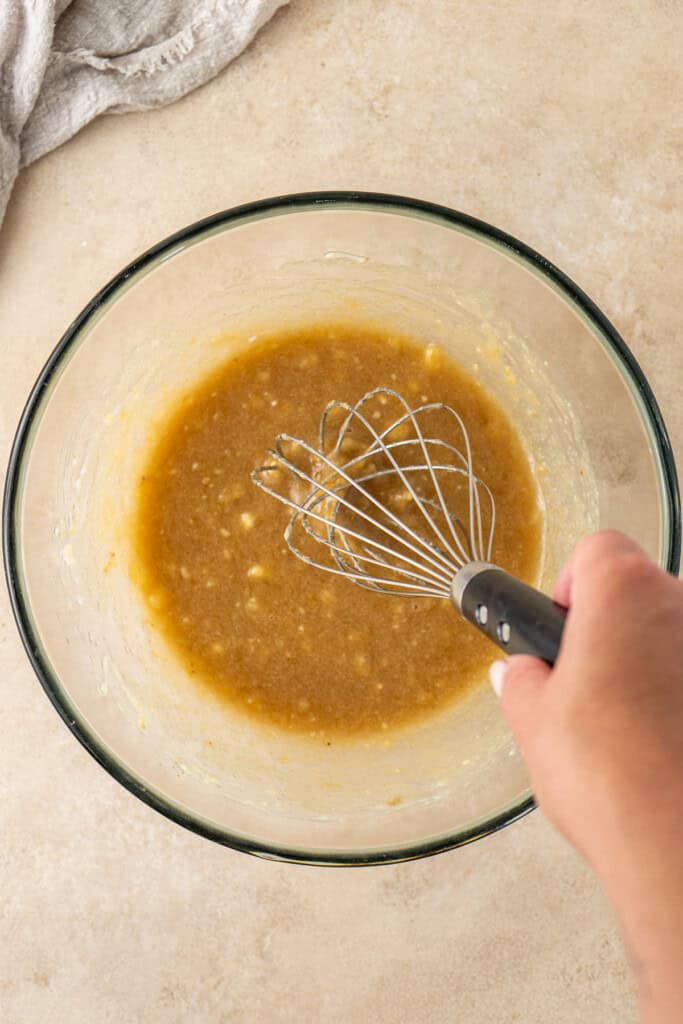 Whisking together the wet ingredients in a bowl.