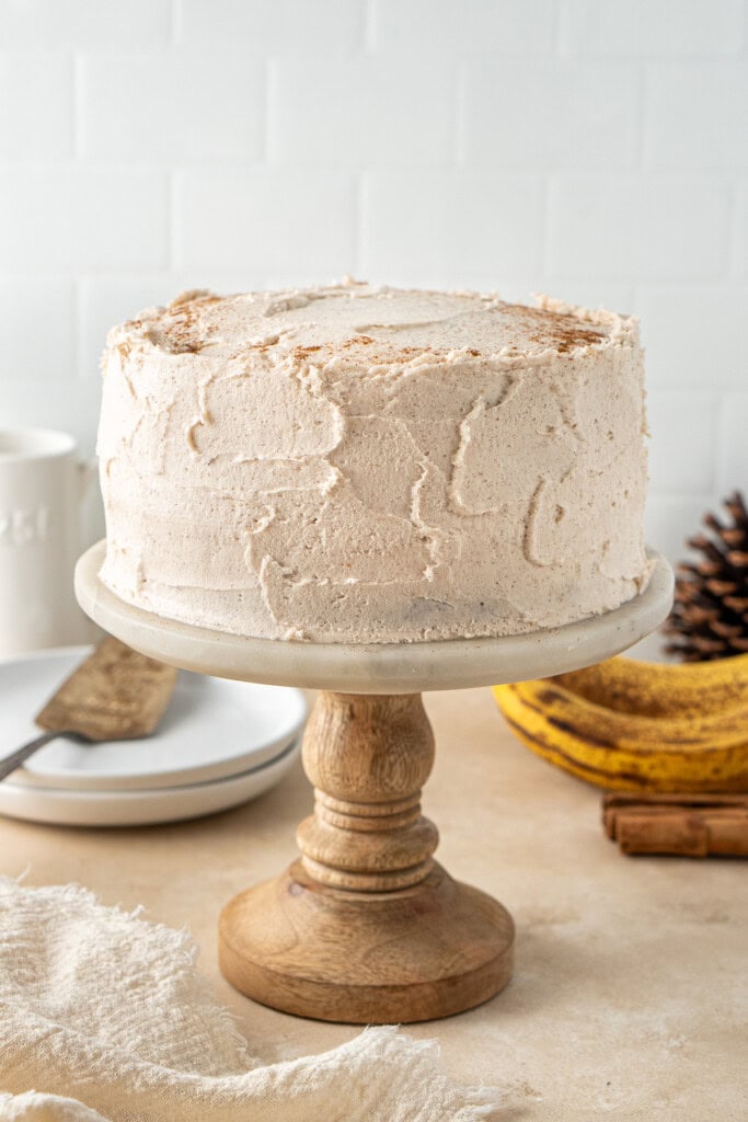 The frosted cake on a cake stand.