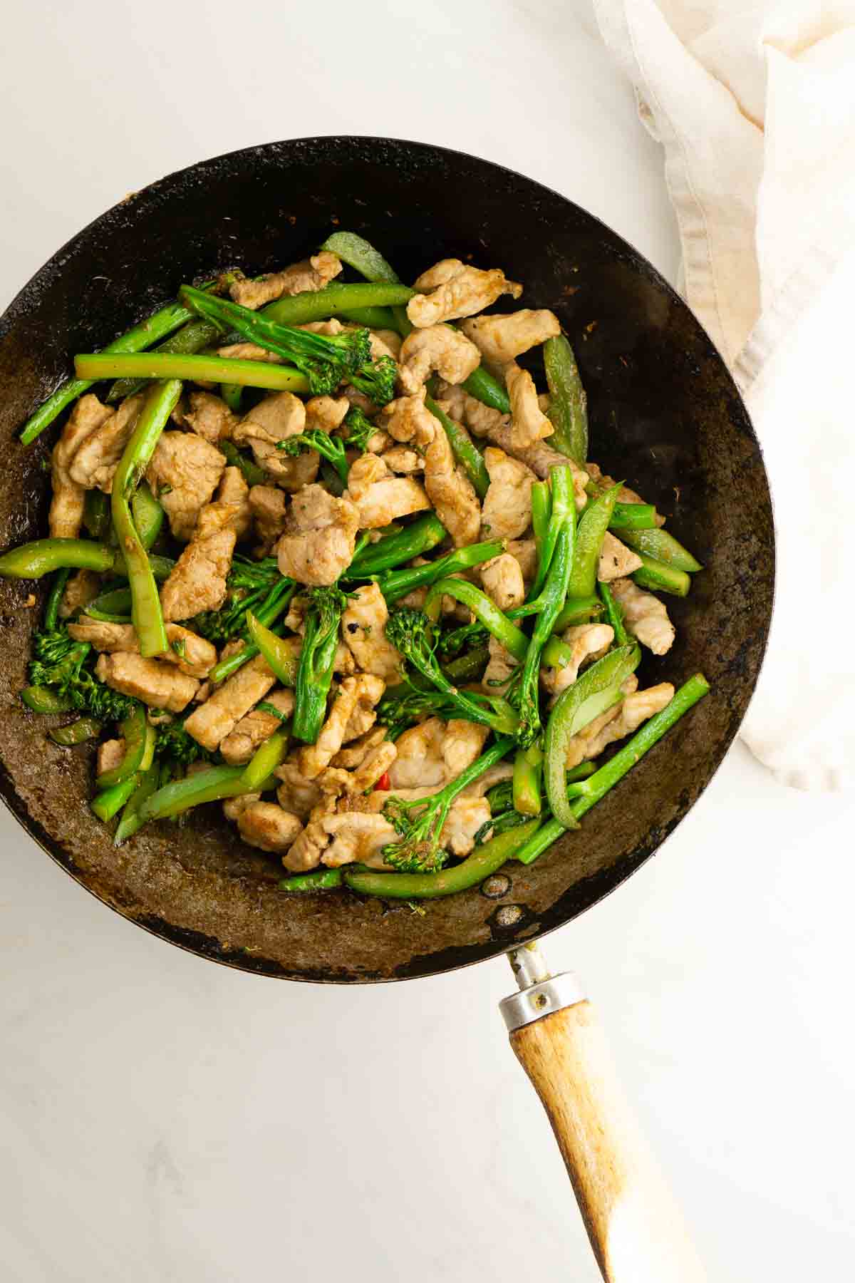 Pork and green vegetables cooked in a wok