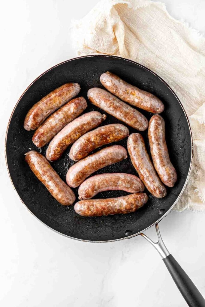 Browning the sausages in a frying pan.