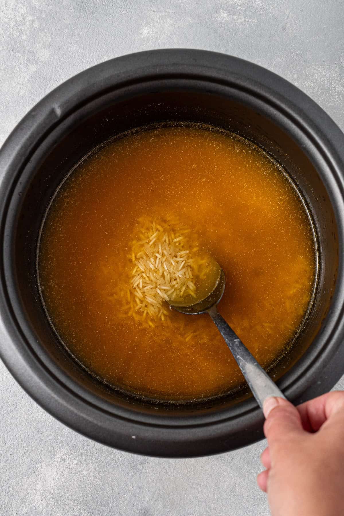Mixing the ingredients with the rice in the rice cooker.