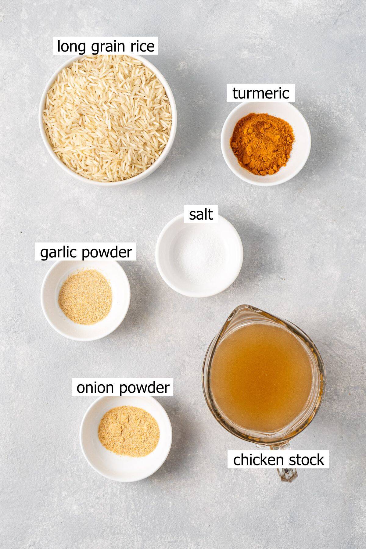 All ingredients needed to make turmeric rice in the rice cooker laid out in bowls.