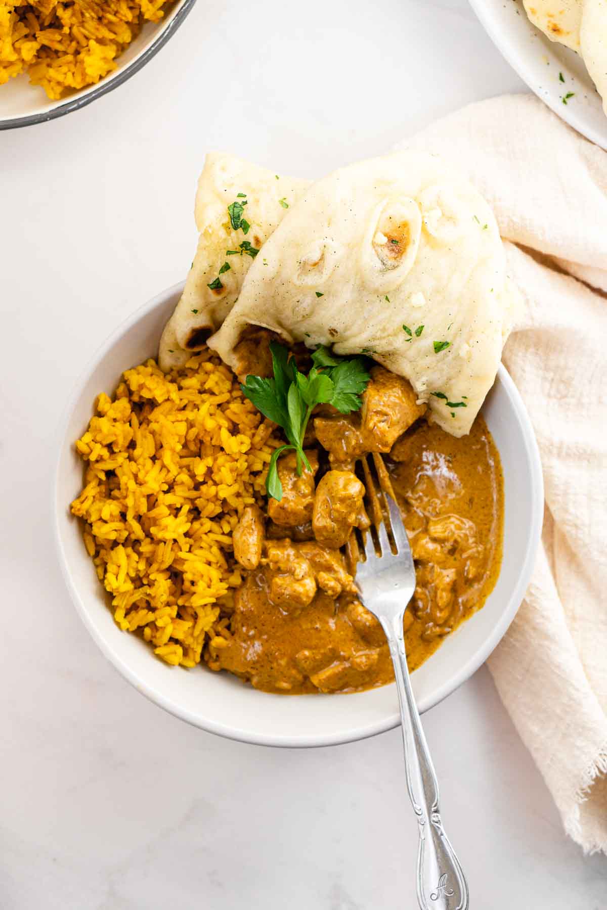 Butter chicken served with naan and turmeric rice.