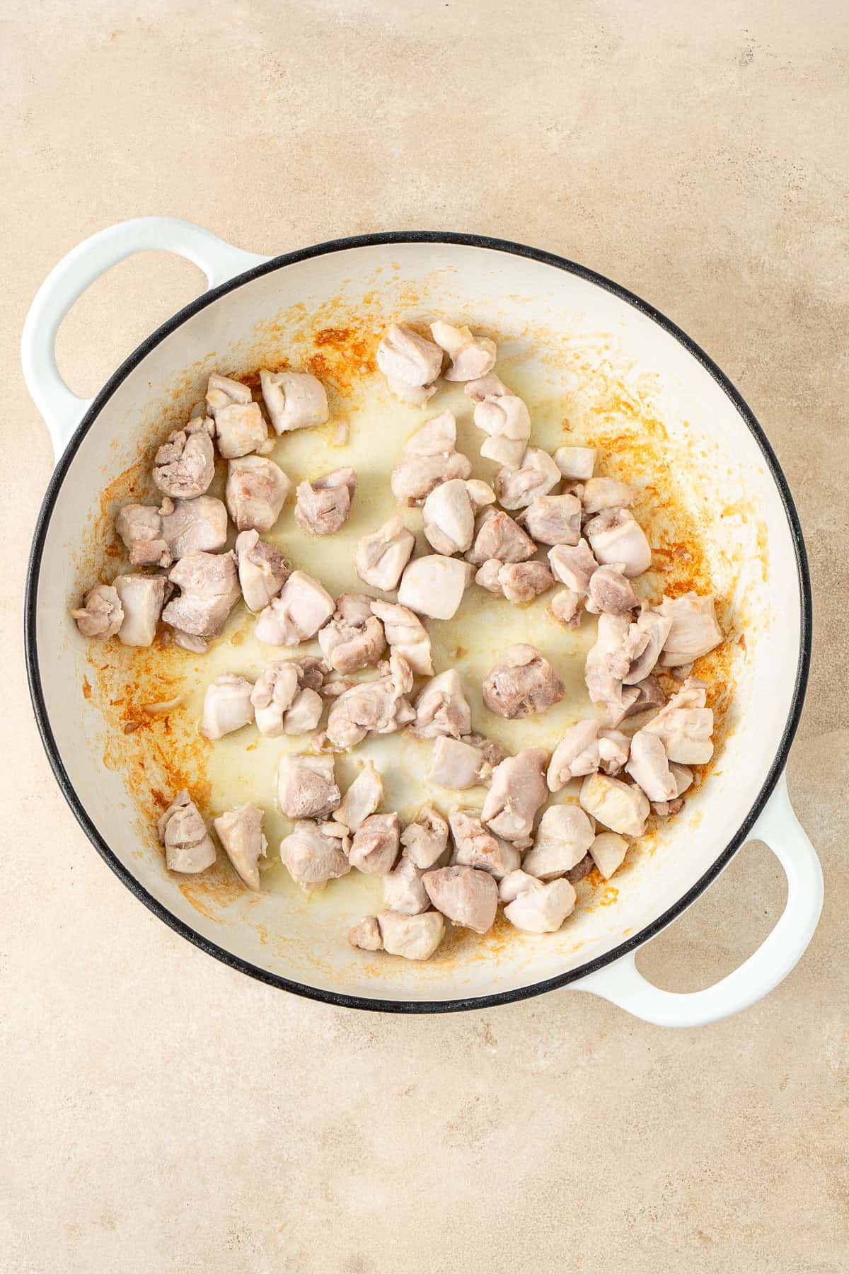 Browning the chicken in a pan.