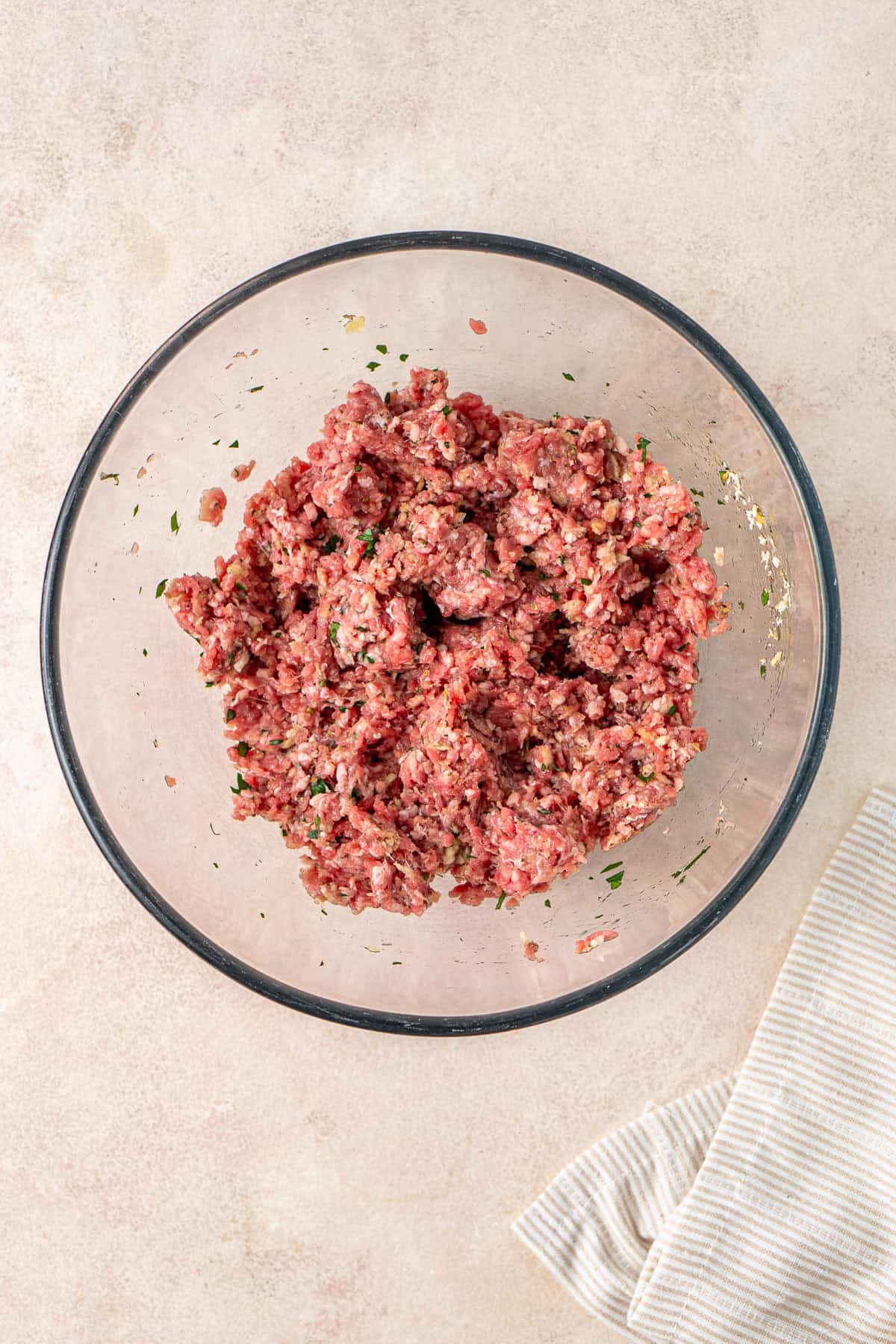 The meatball mixture mixed together in a glass bowl.