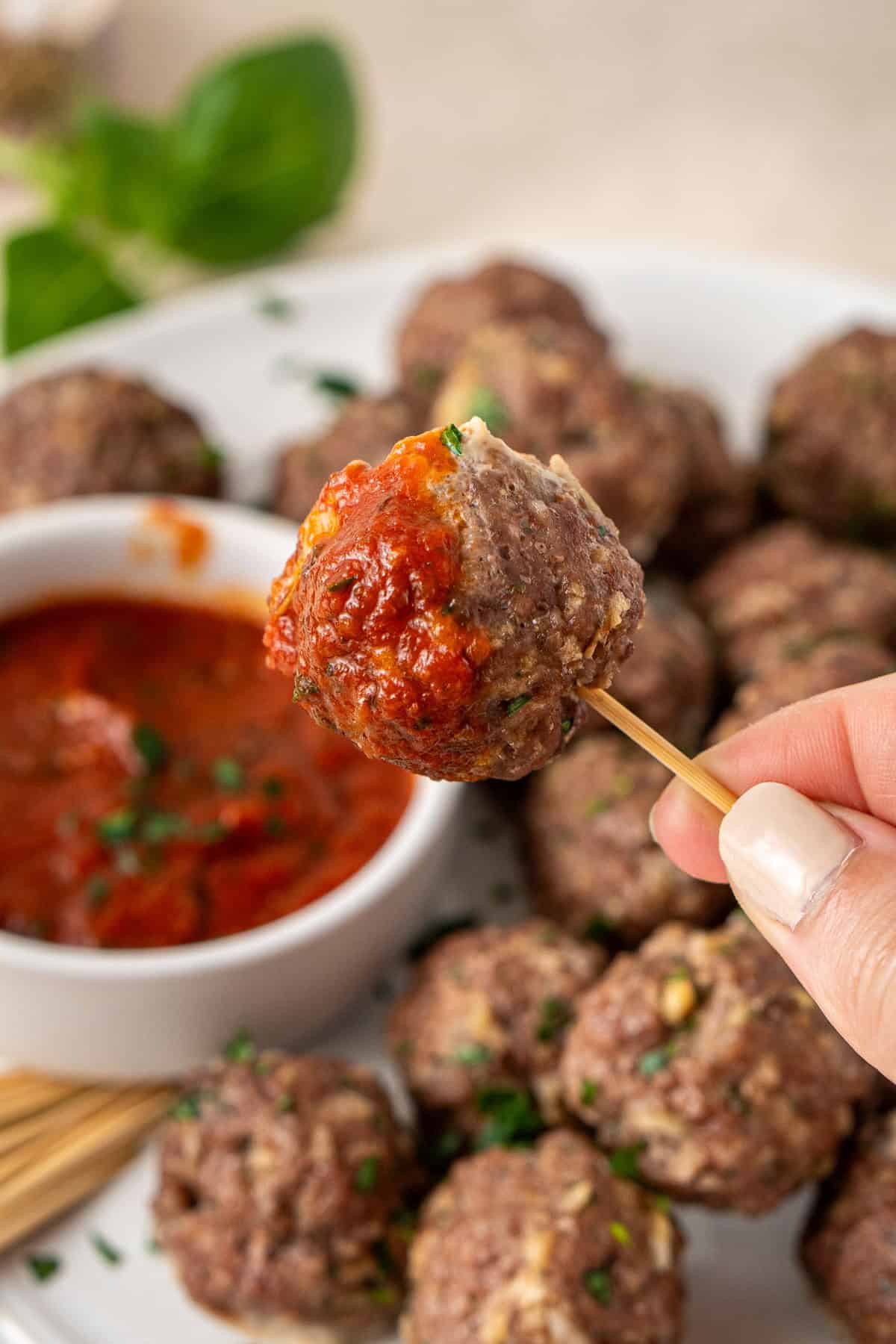 The meatball dipped in the marinara sauce.