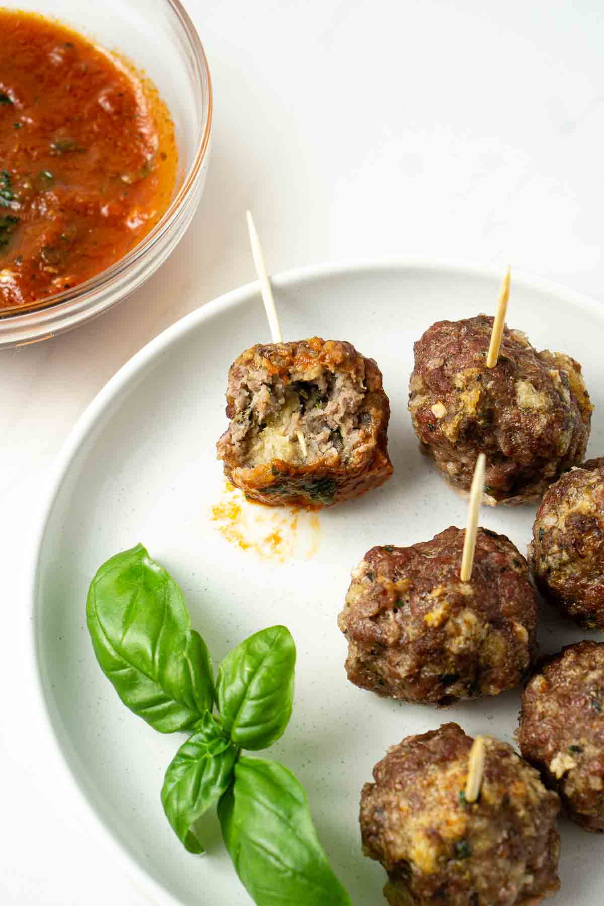Meatballs on a plate with one that has a bite taken