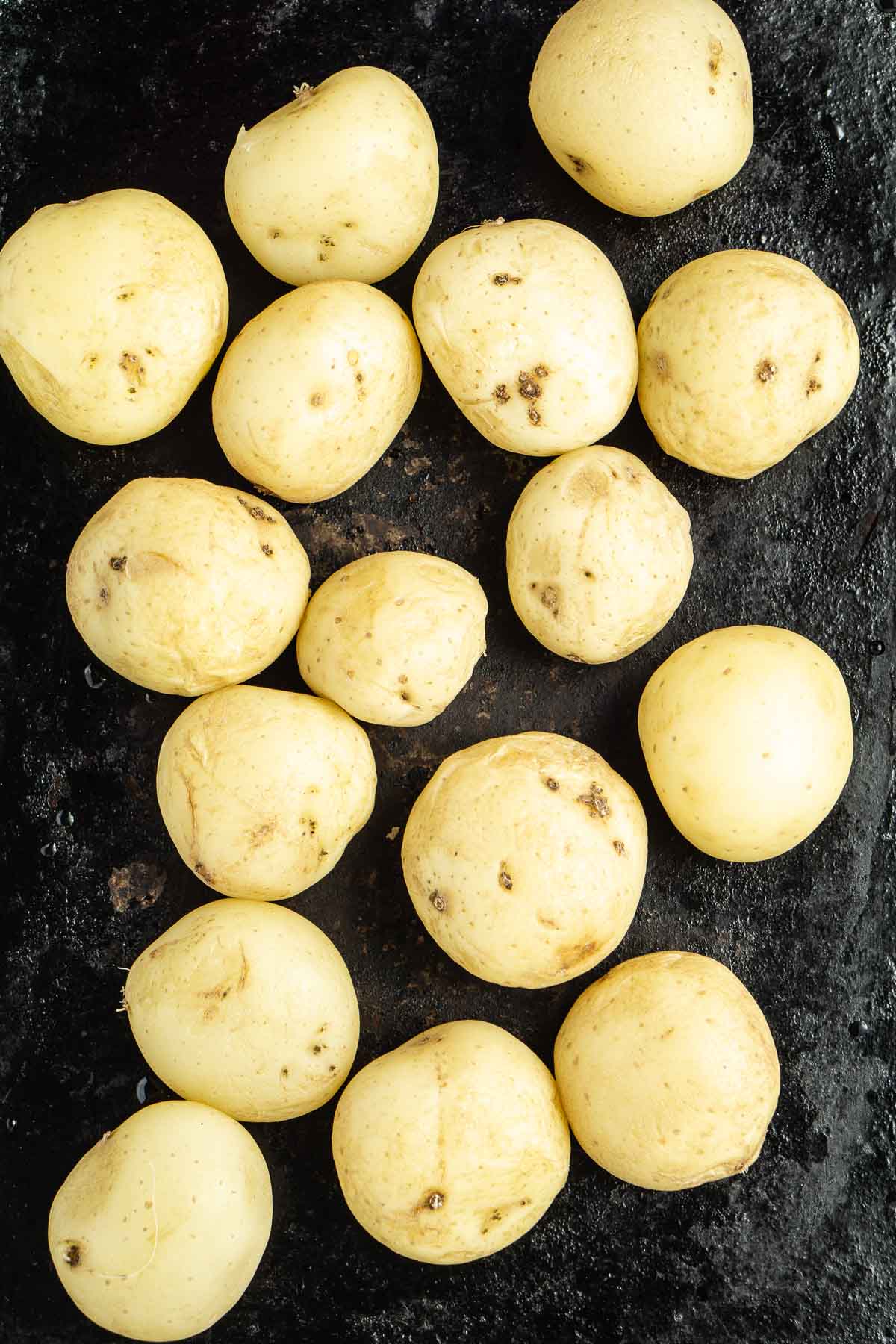 Boiled potatoes on a baking tray