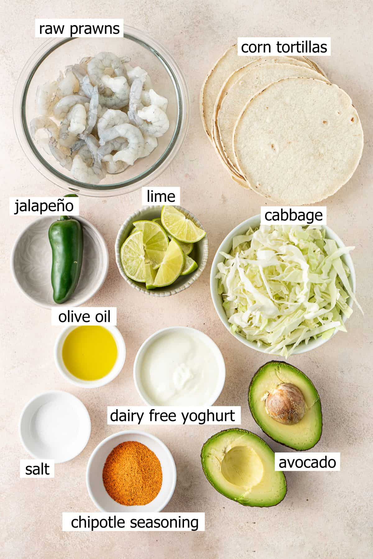 All ingredients needed to make grilled prawn tacos laid out in small bowls.