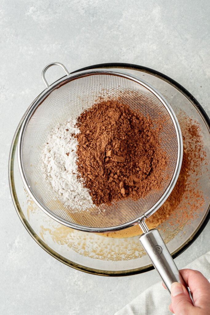 Sifting the dry ingredients into the mixing bowl.