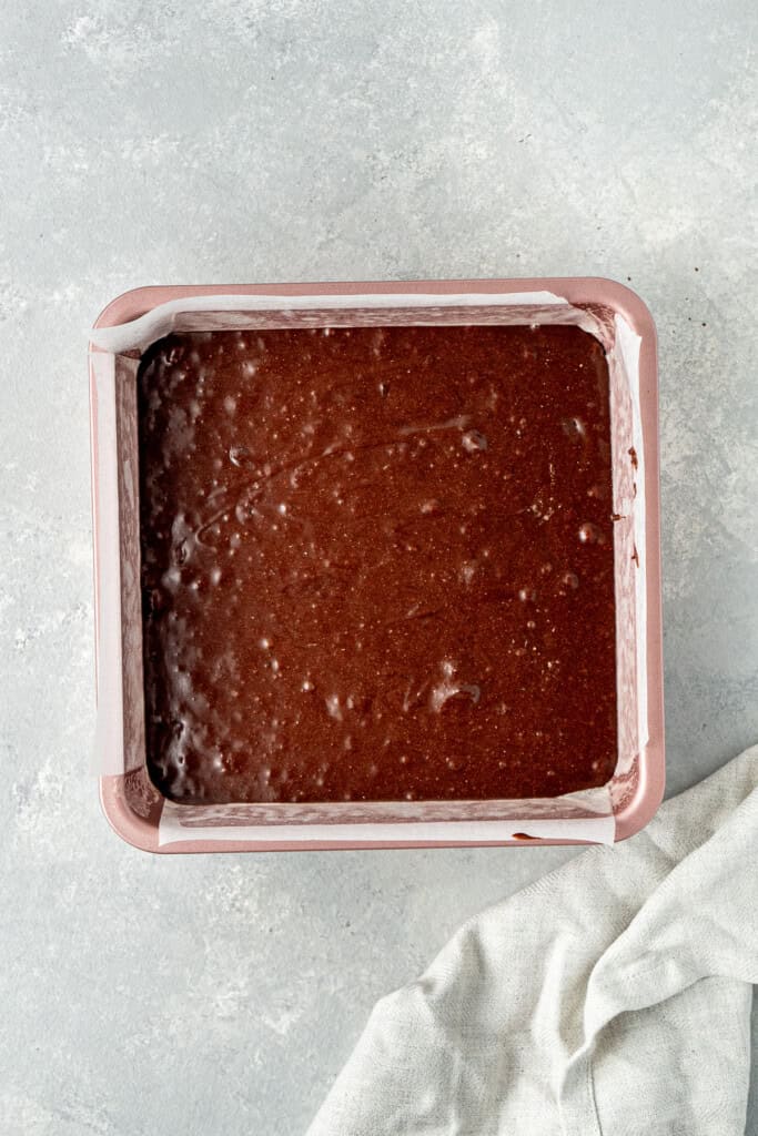 The brownie batter in a square baking pan.