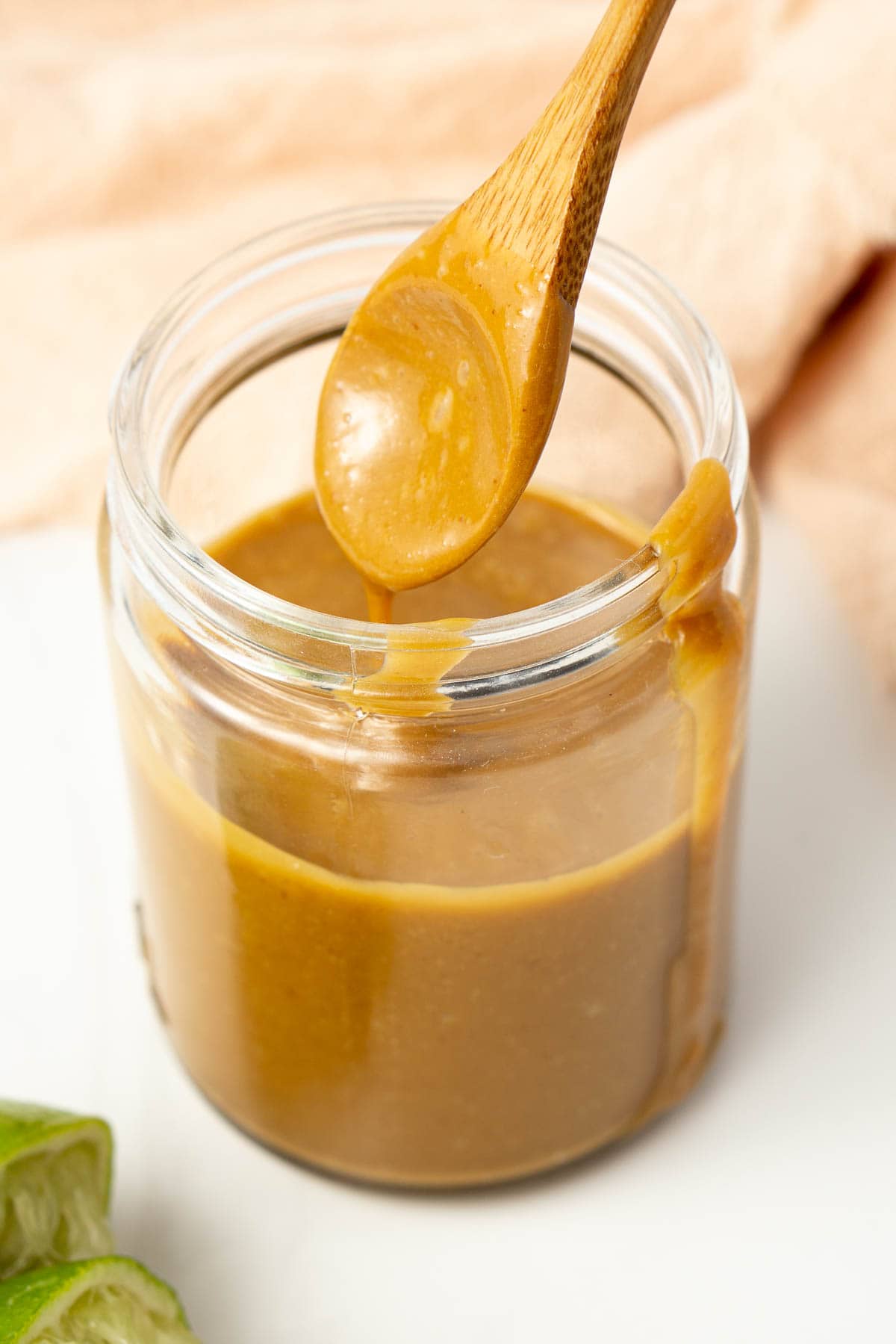 Peanut sauce in a glass jar with a spoon.