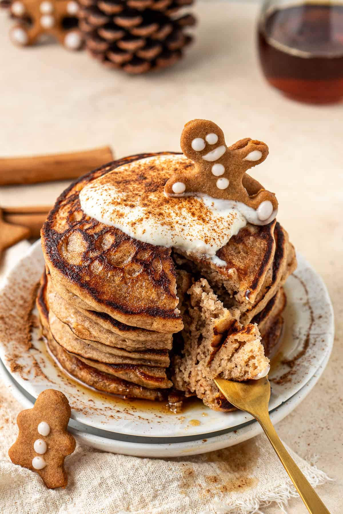 A stack of gingerbread pancakes topped with yoghurt and a gingerbread biscuit.