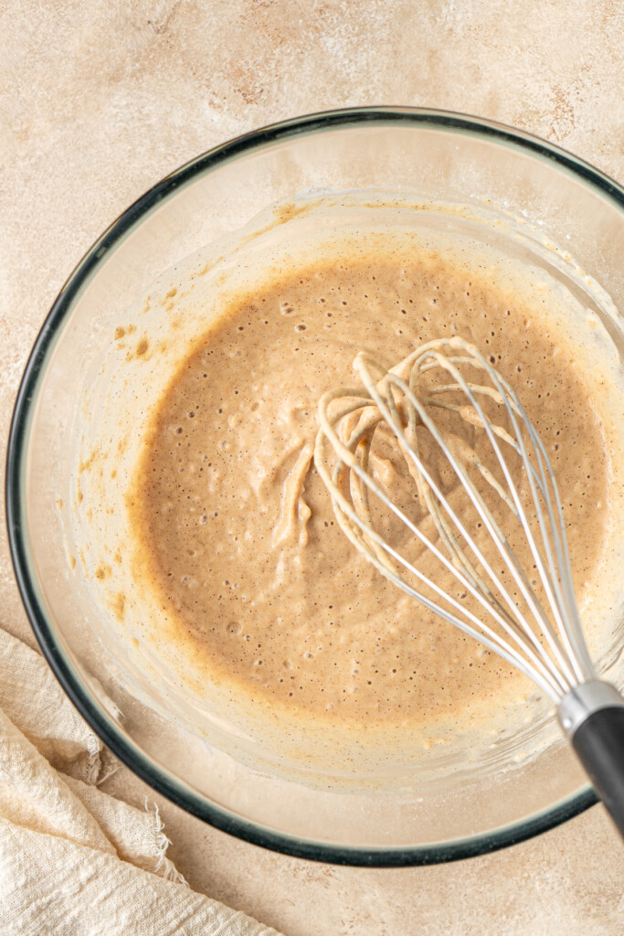 The pancake batter in a bowl with a whisk.