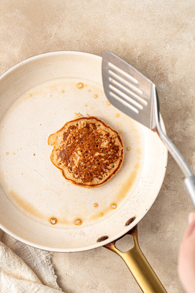 Flipping a pancake with a metal spatula. 