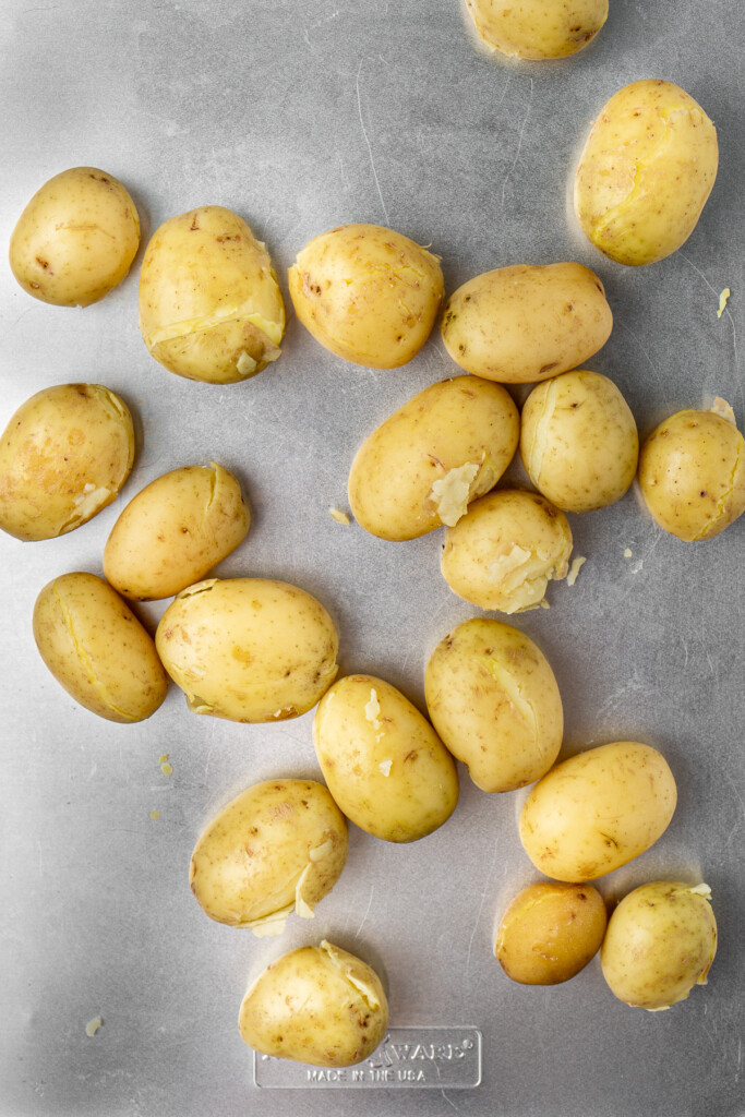 Cooked potatoes on a baking tray.