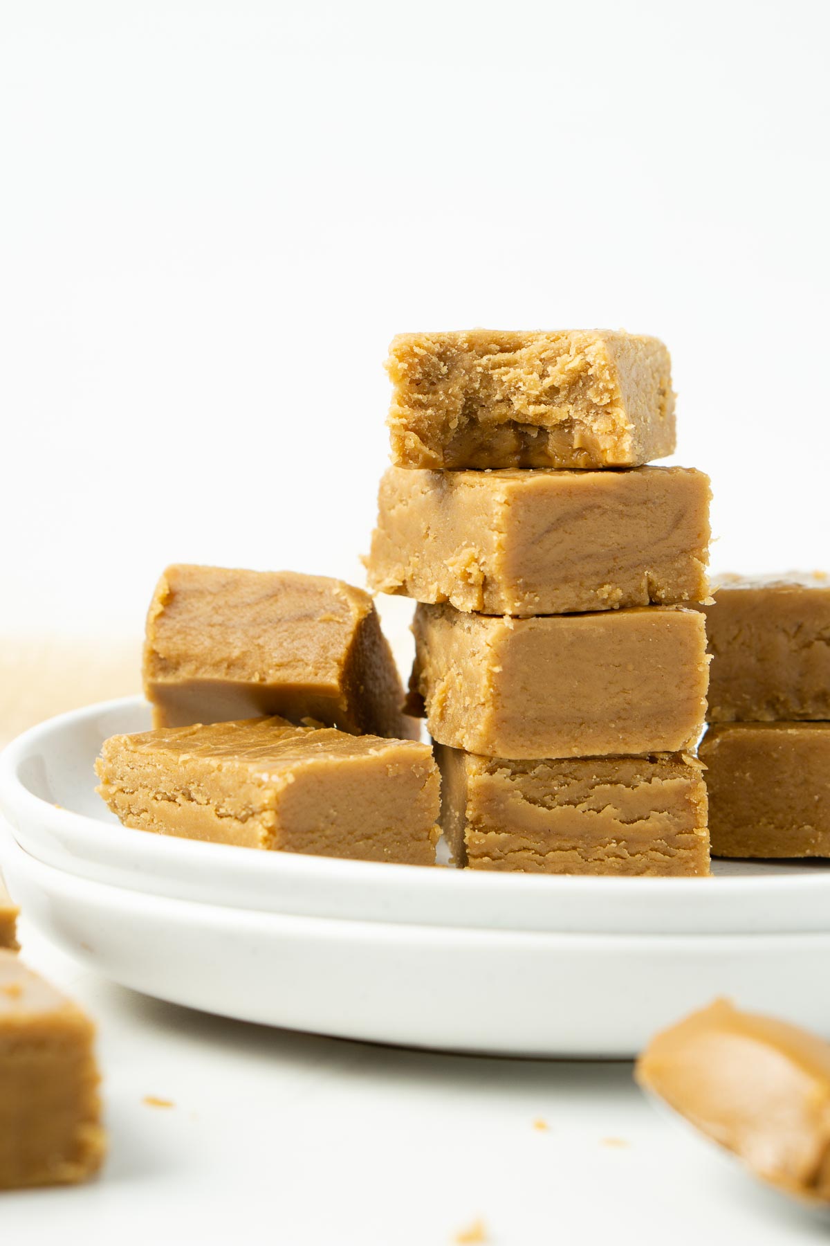 Vegan biscoff fudge on a plate with a bite taken