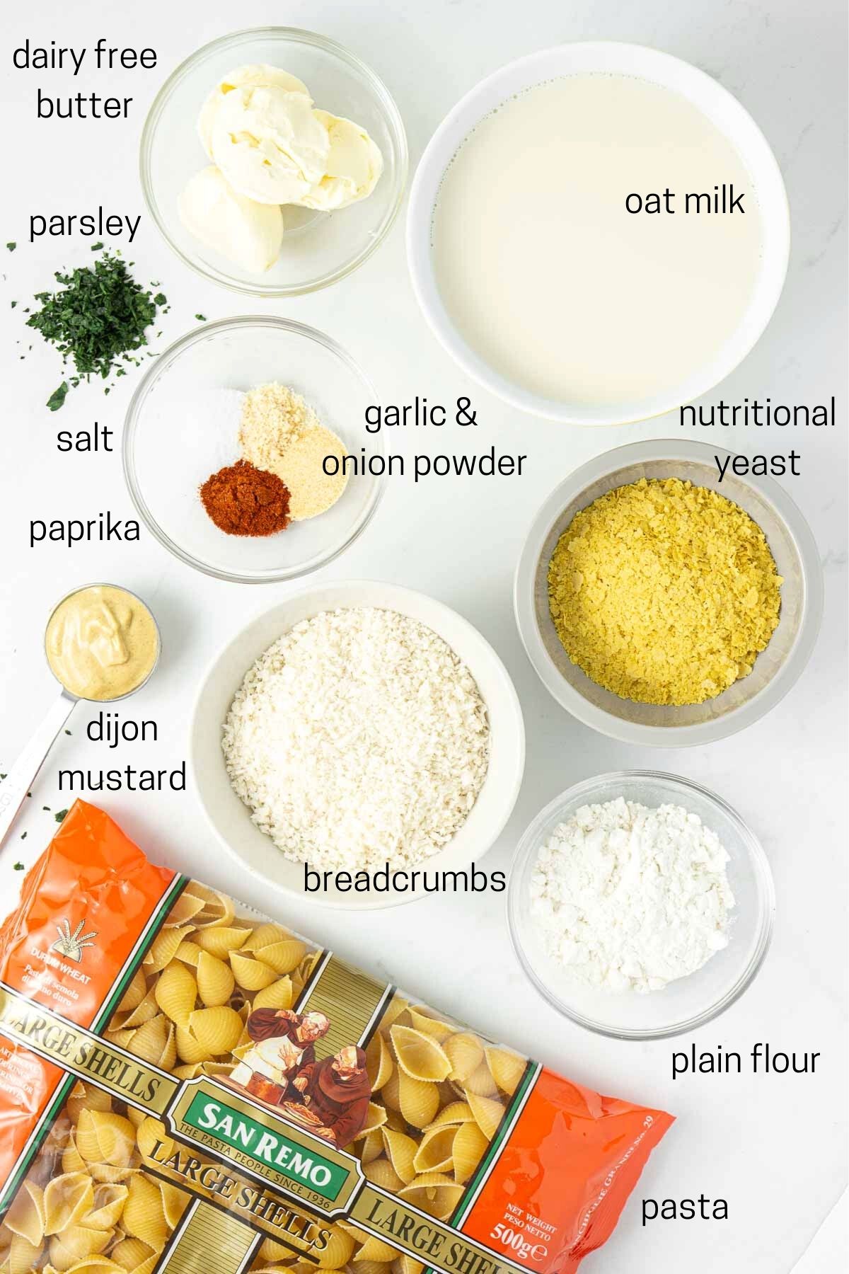 All ingredients for dairy-free mac and cheese laid out in small bowls.