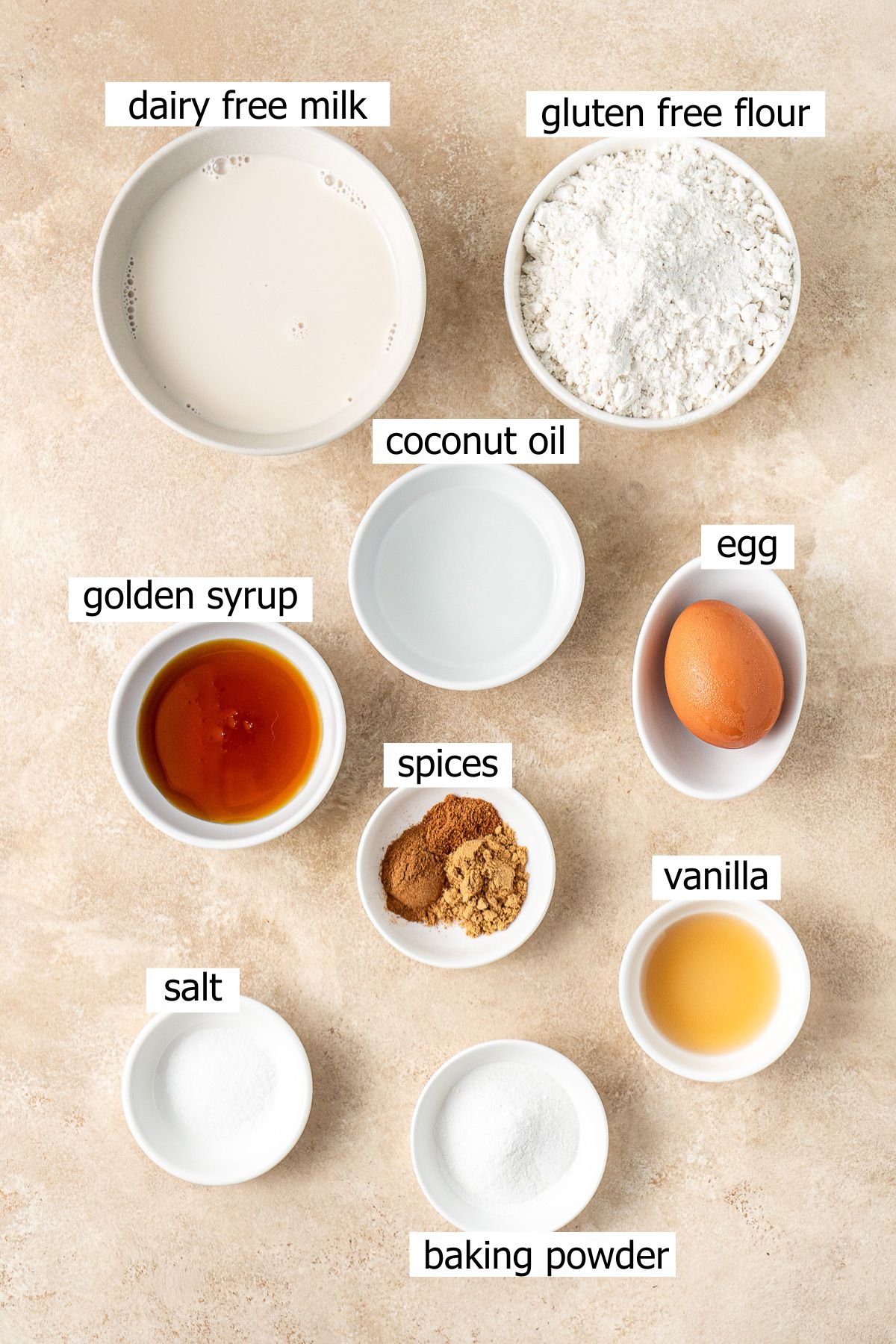 All ingredients needed to make gingerbread pancakes laid out in bowls.