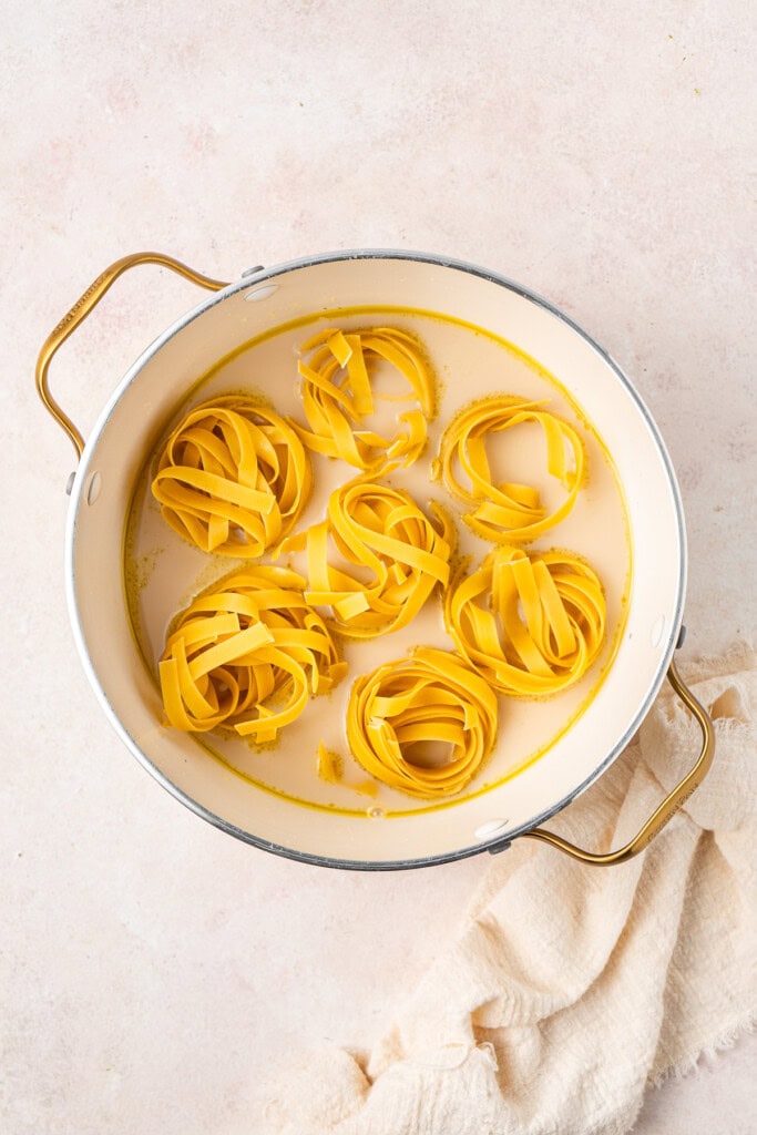 Adding the tagliatelle into the oat milk and stock in the pot.