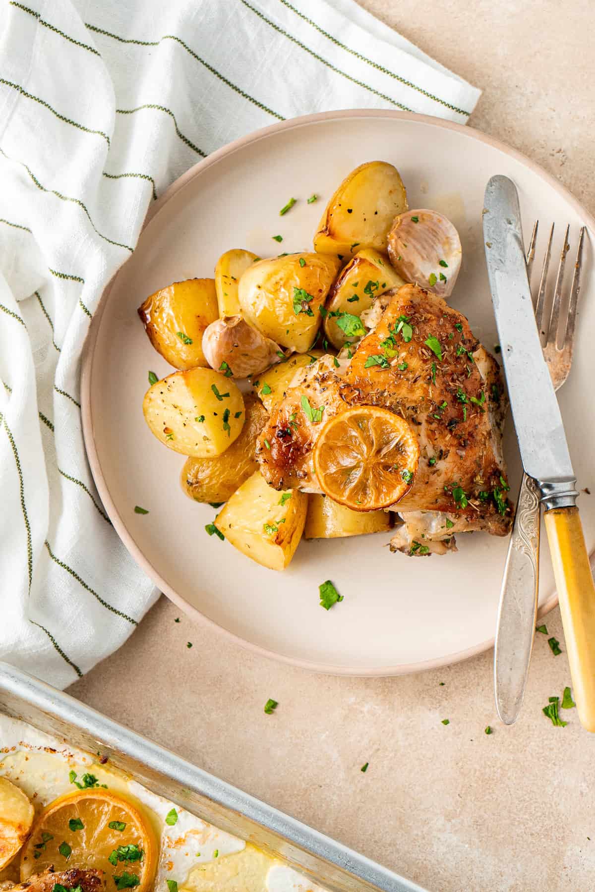 Roast lemon and garlic chicken and potatoes on a plate.