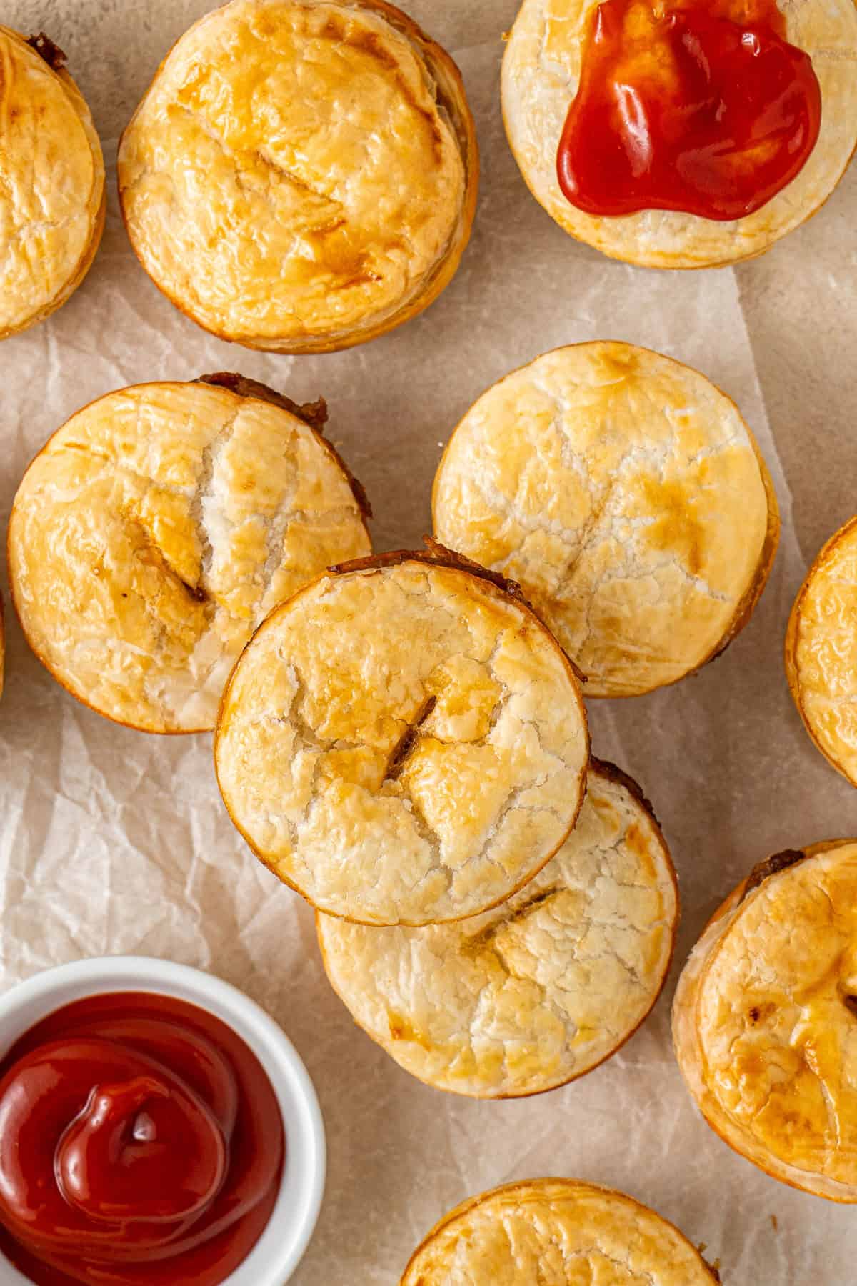 Mini beef pies with tomato sauce.