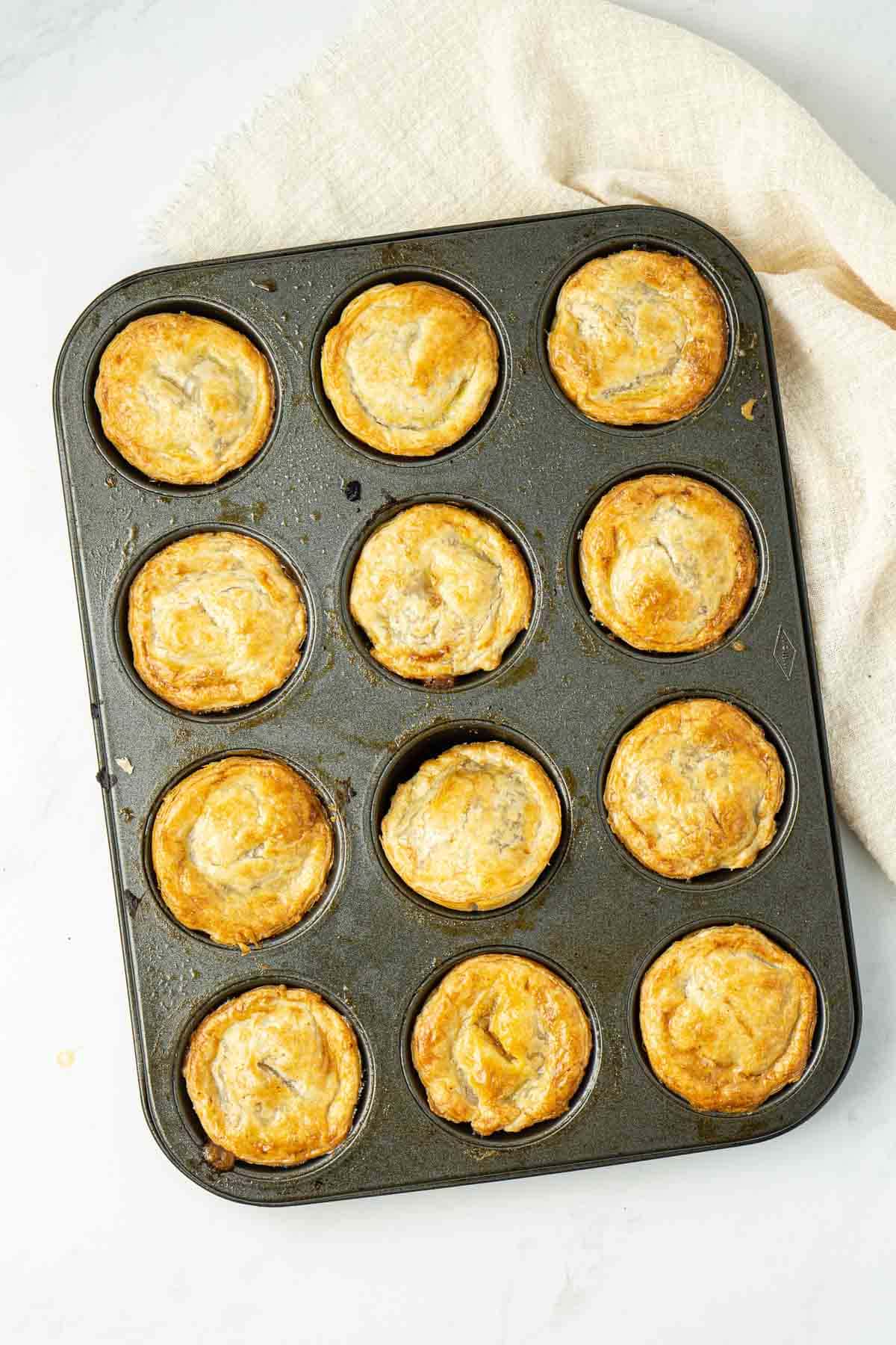 Cooked pies in a muffin pan, fresh from the oven.
