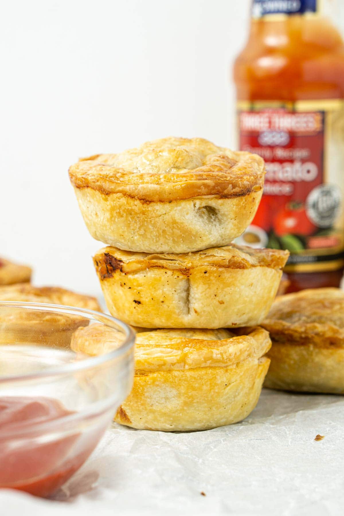 Three mini beef pies stacked on top of each other.