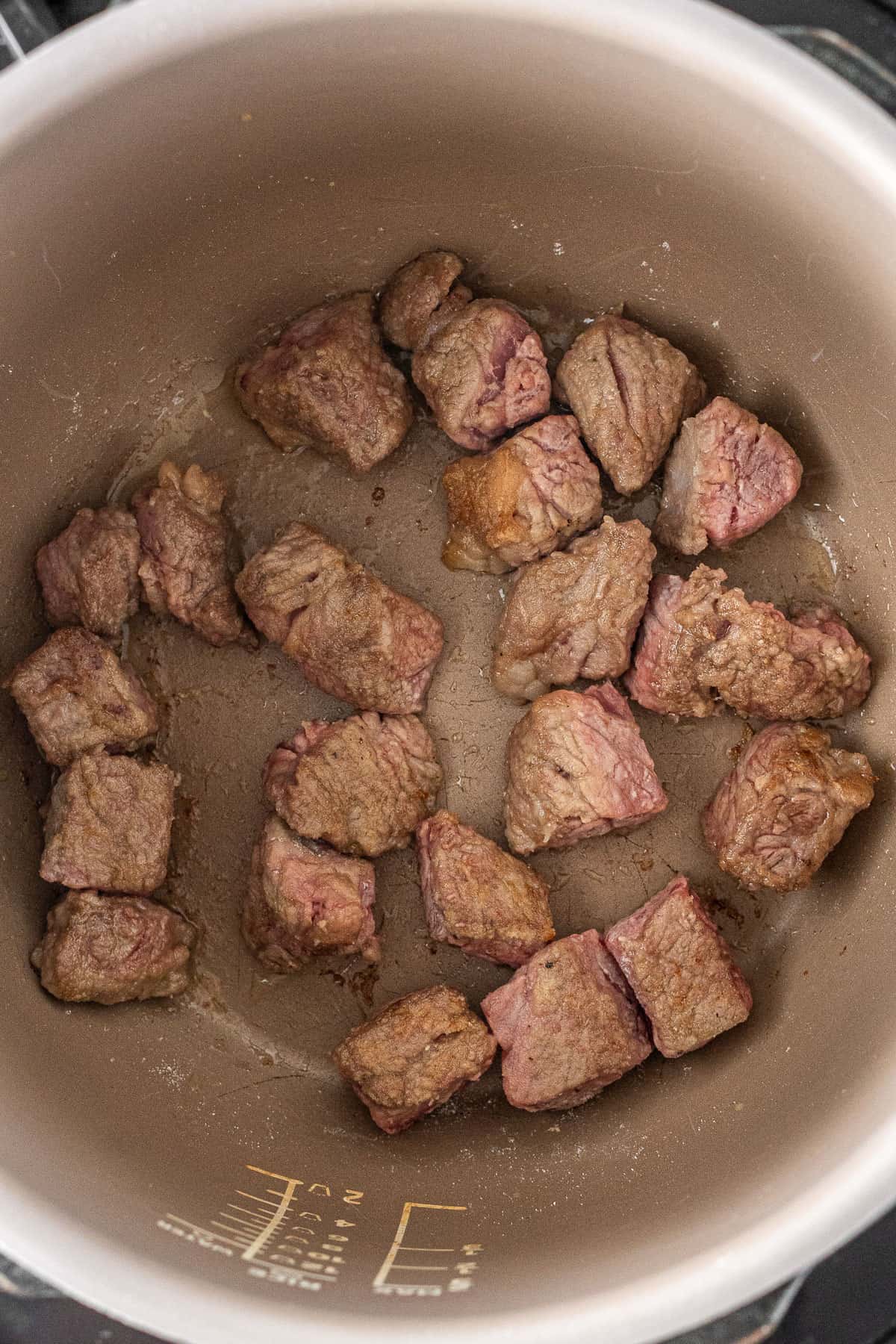 Browning the beef in batches in the pressure cooker.