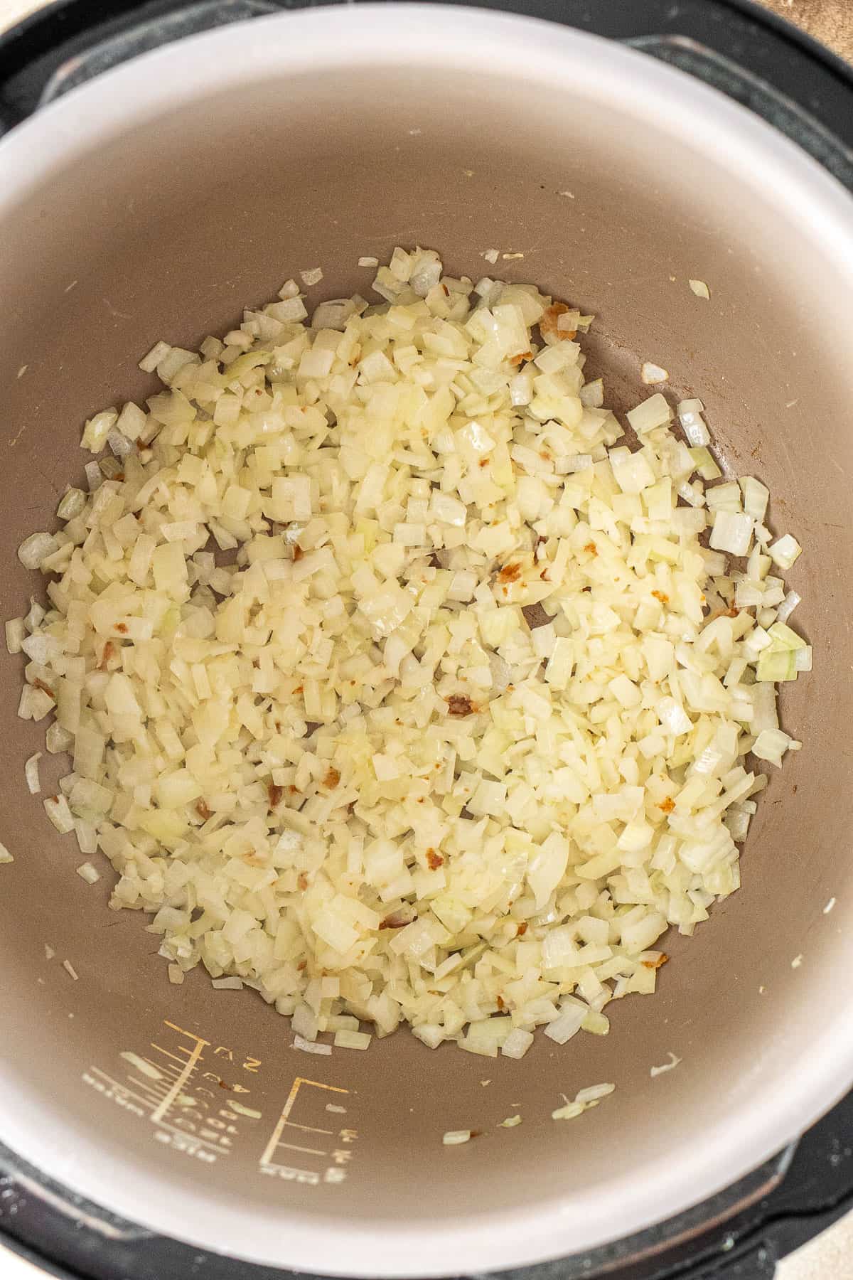 Cooking the onion and garlic in the pressure cooker.