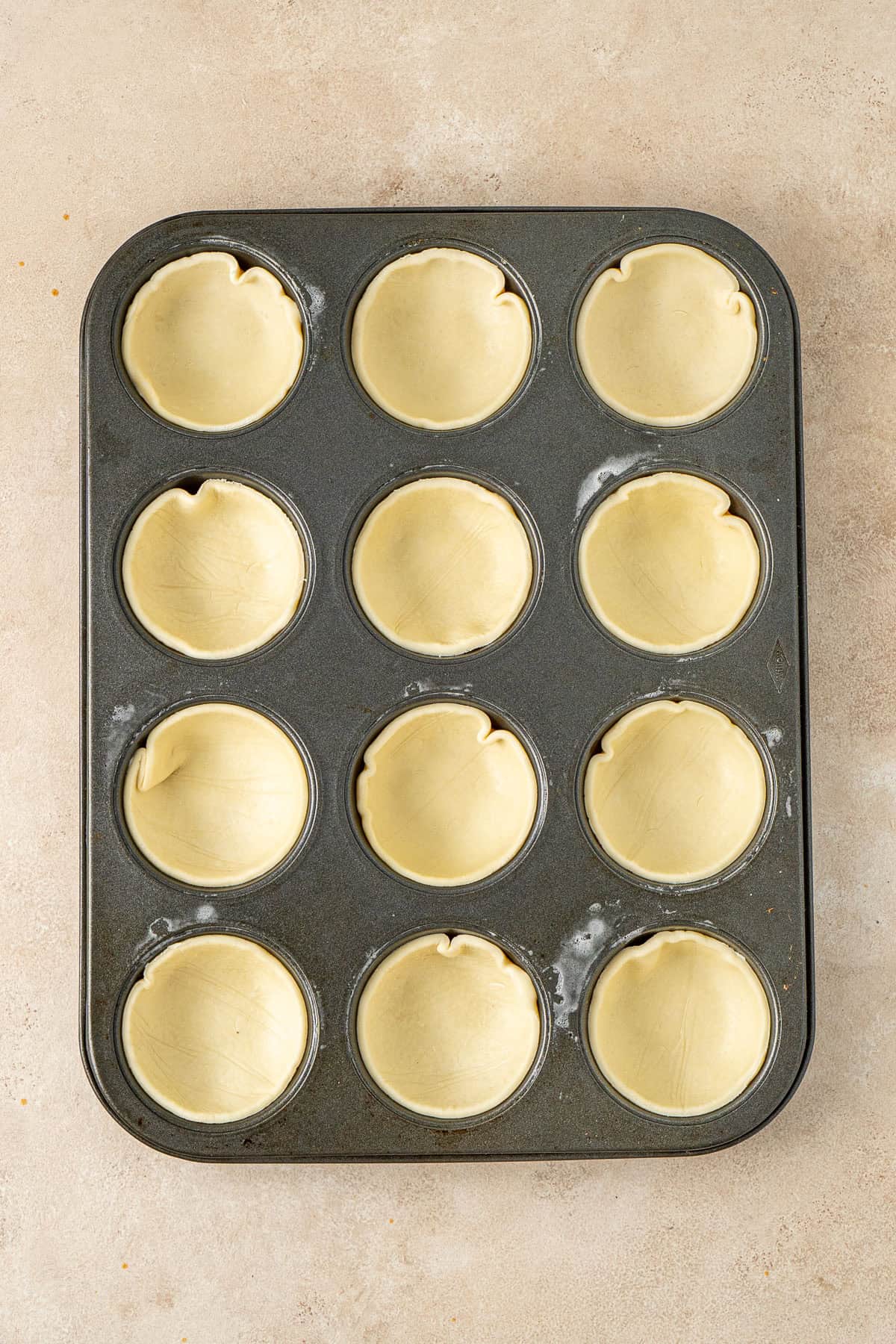 The pastry rounds in the muffin tin.
