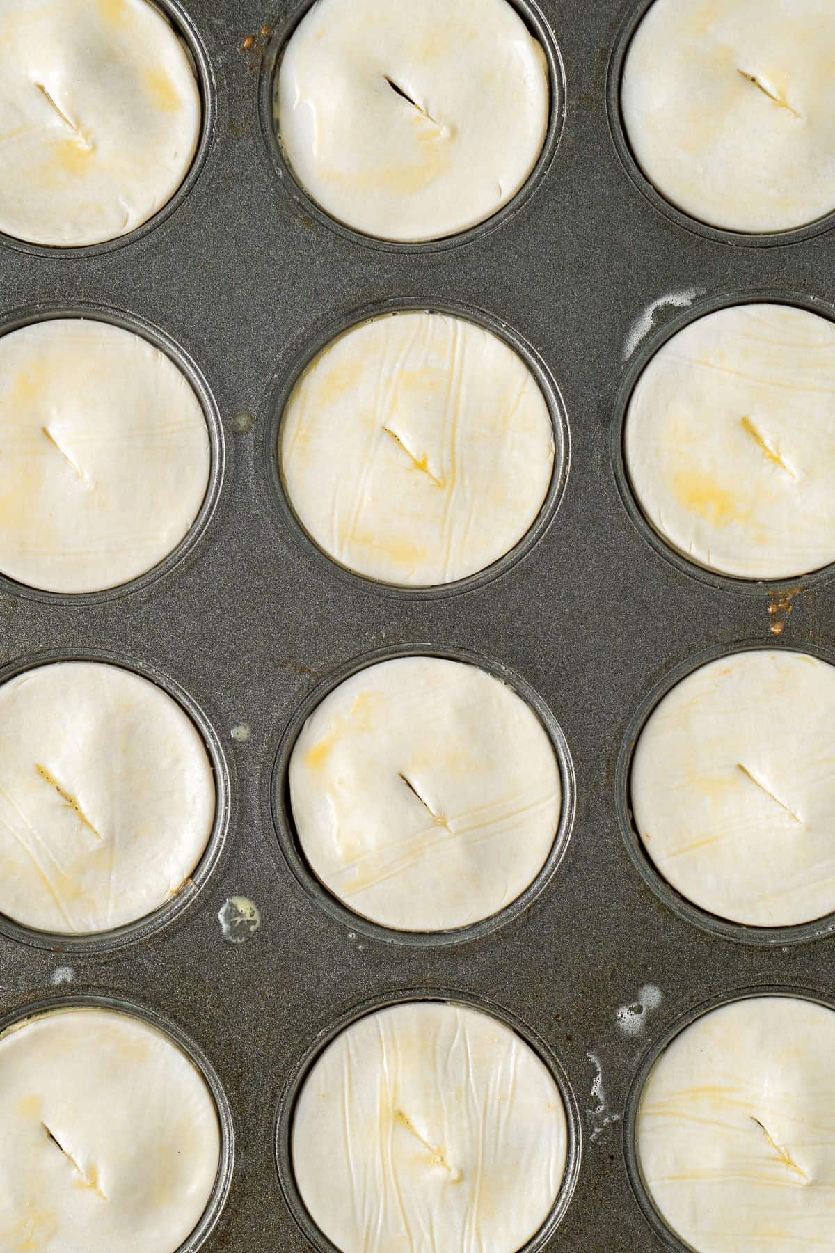 The pastry on top of the pies and brushed with egg.