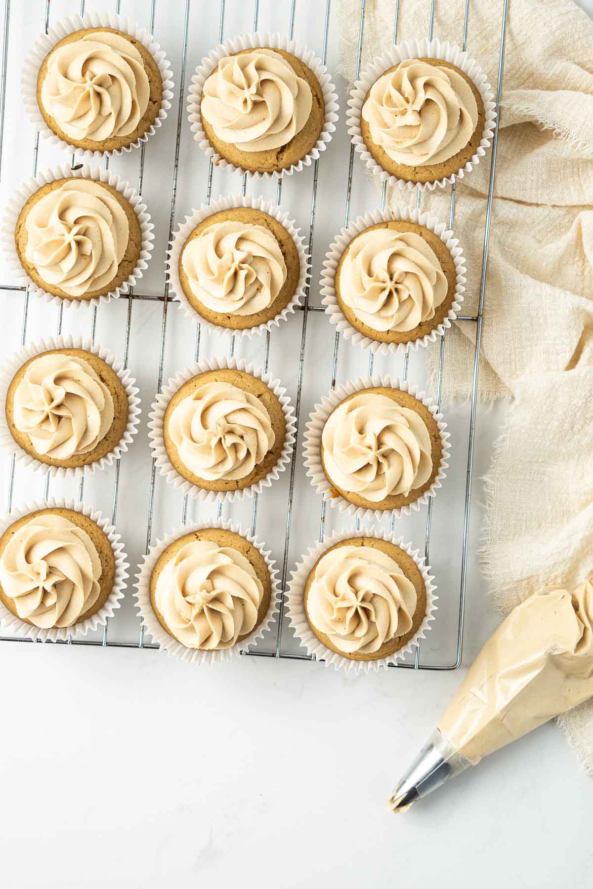 Cupcakes on a wire rack with swirls of biscoff buttercream from above.