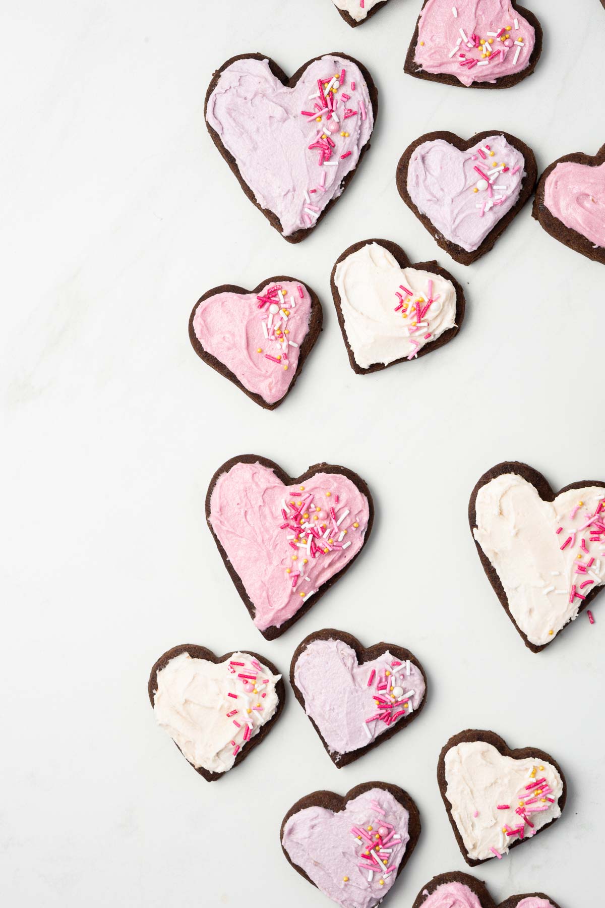 Pink and purple iced chocolate sugar cookies with sprinkles.