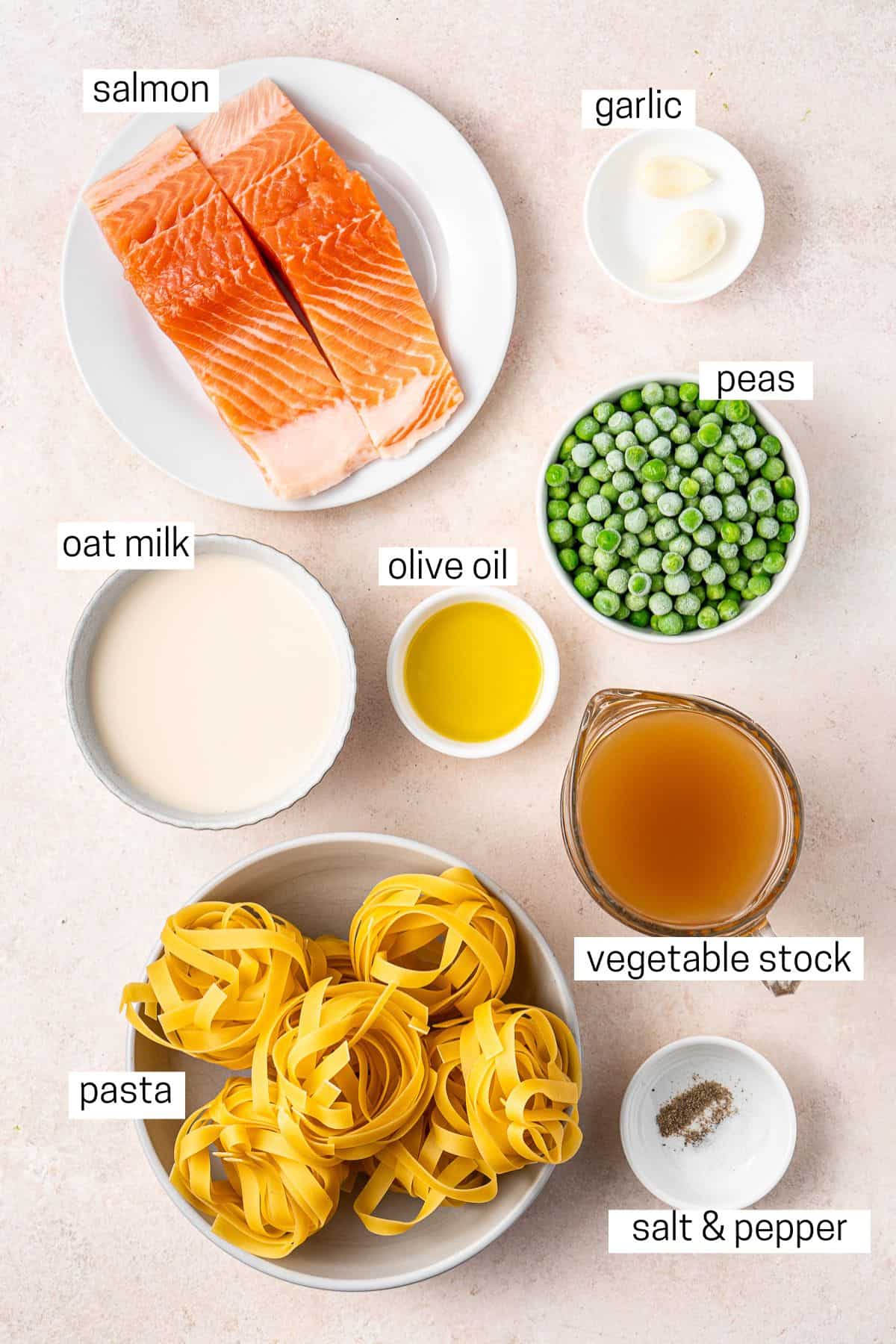 All ingredients needed to make dairy free salmon pasta laid out in bowls.