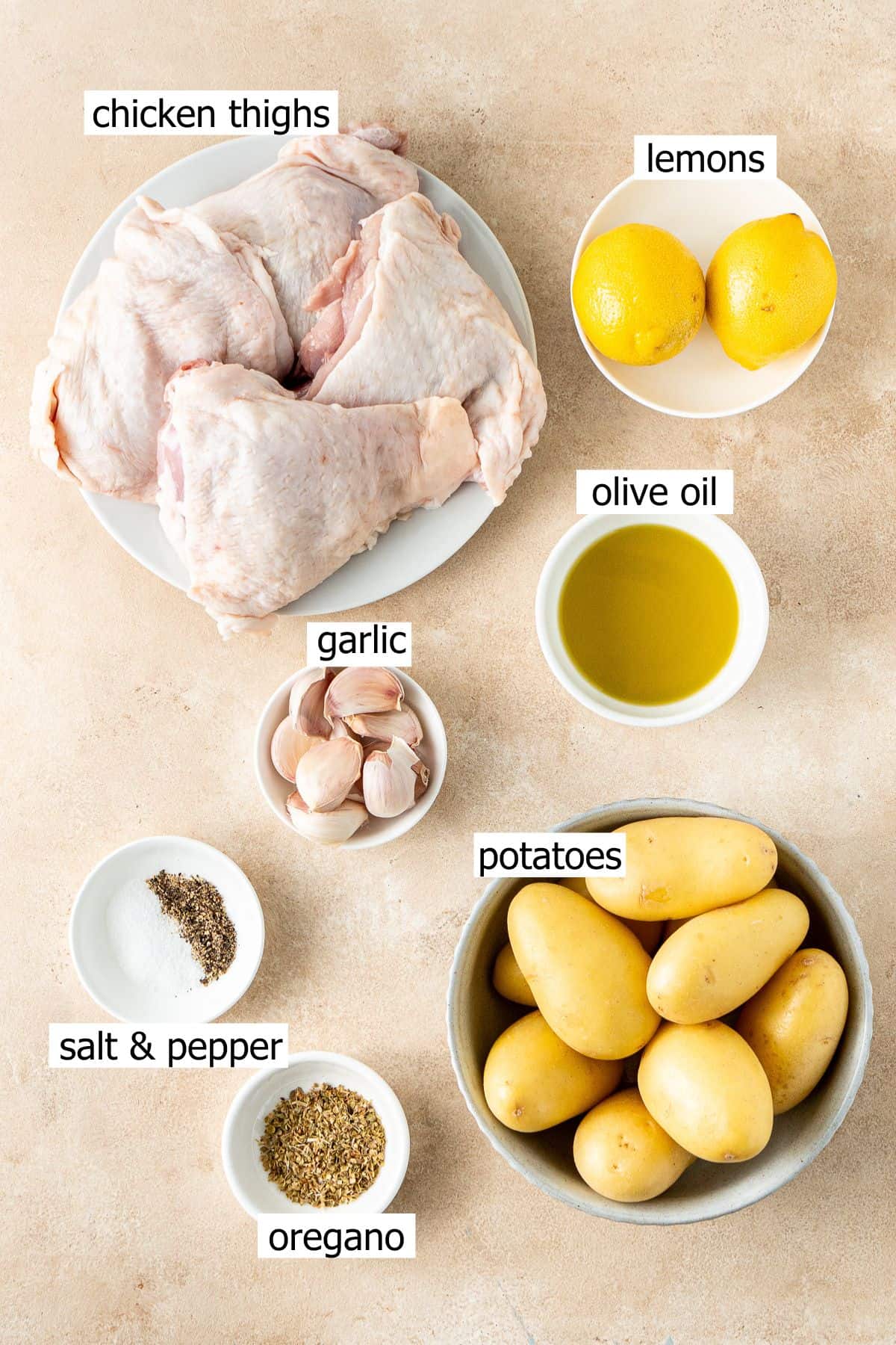 All ingredients needed to make garlic and lemon chicken tray bake laid out in bowls.