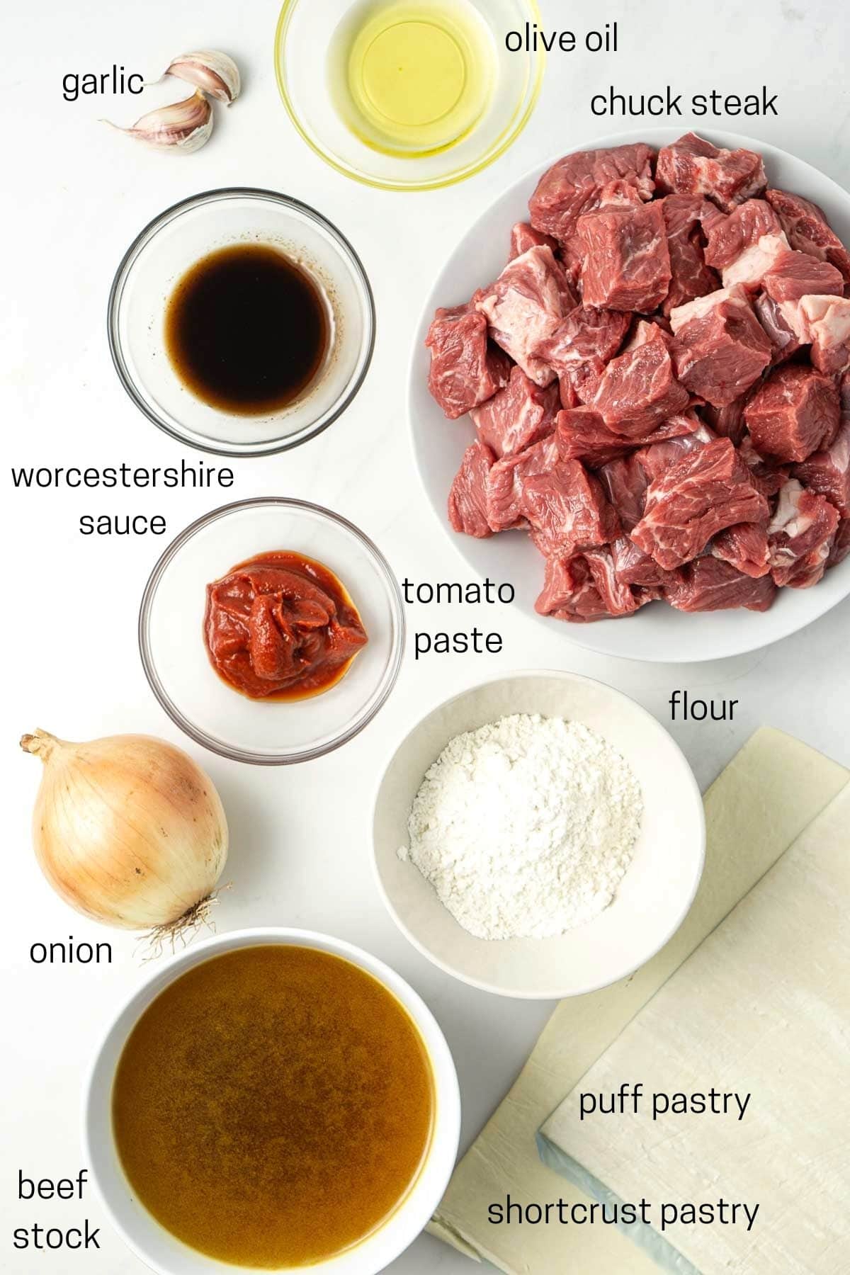 All ingredients needed to make mini beef pies laid out in small bowls.