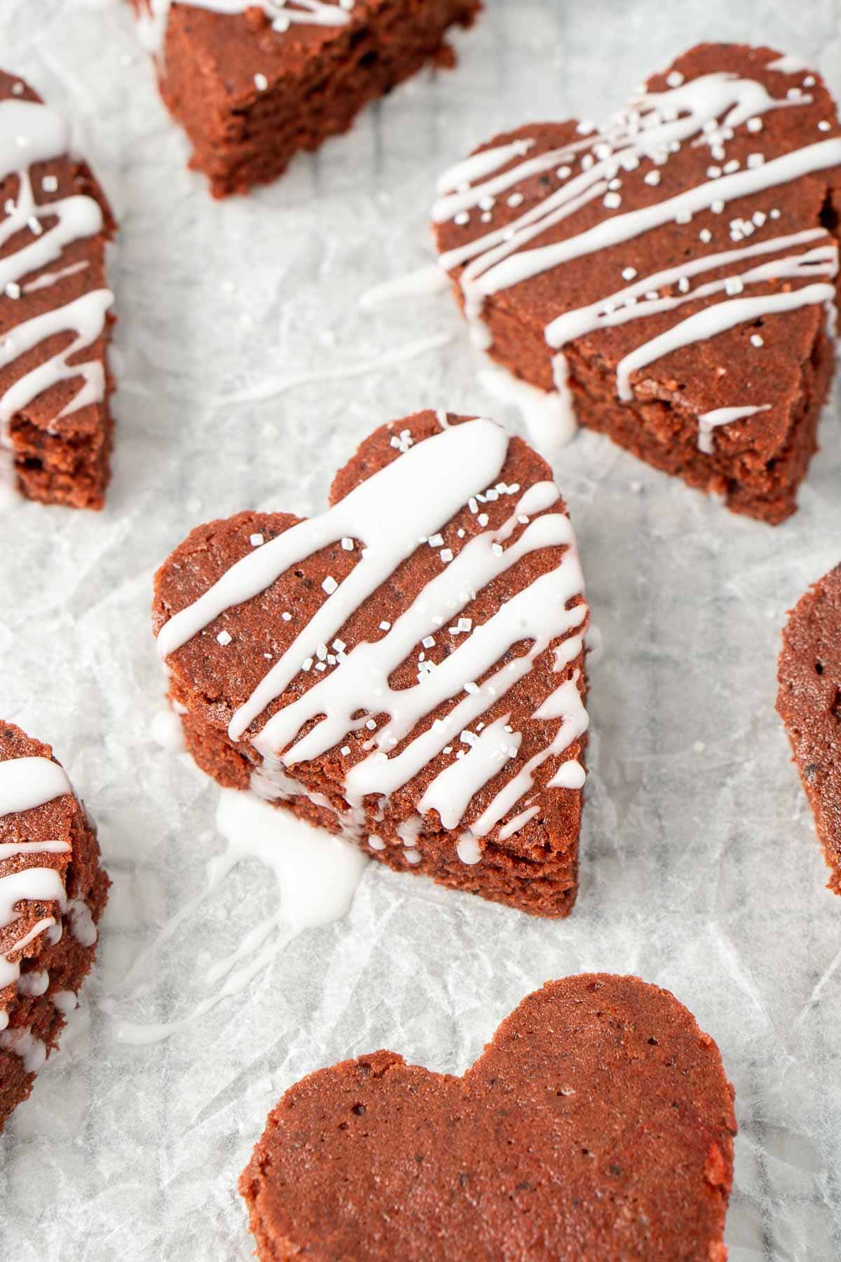 Close up of heart-shaped red velvet brownies with white icing.