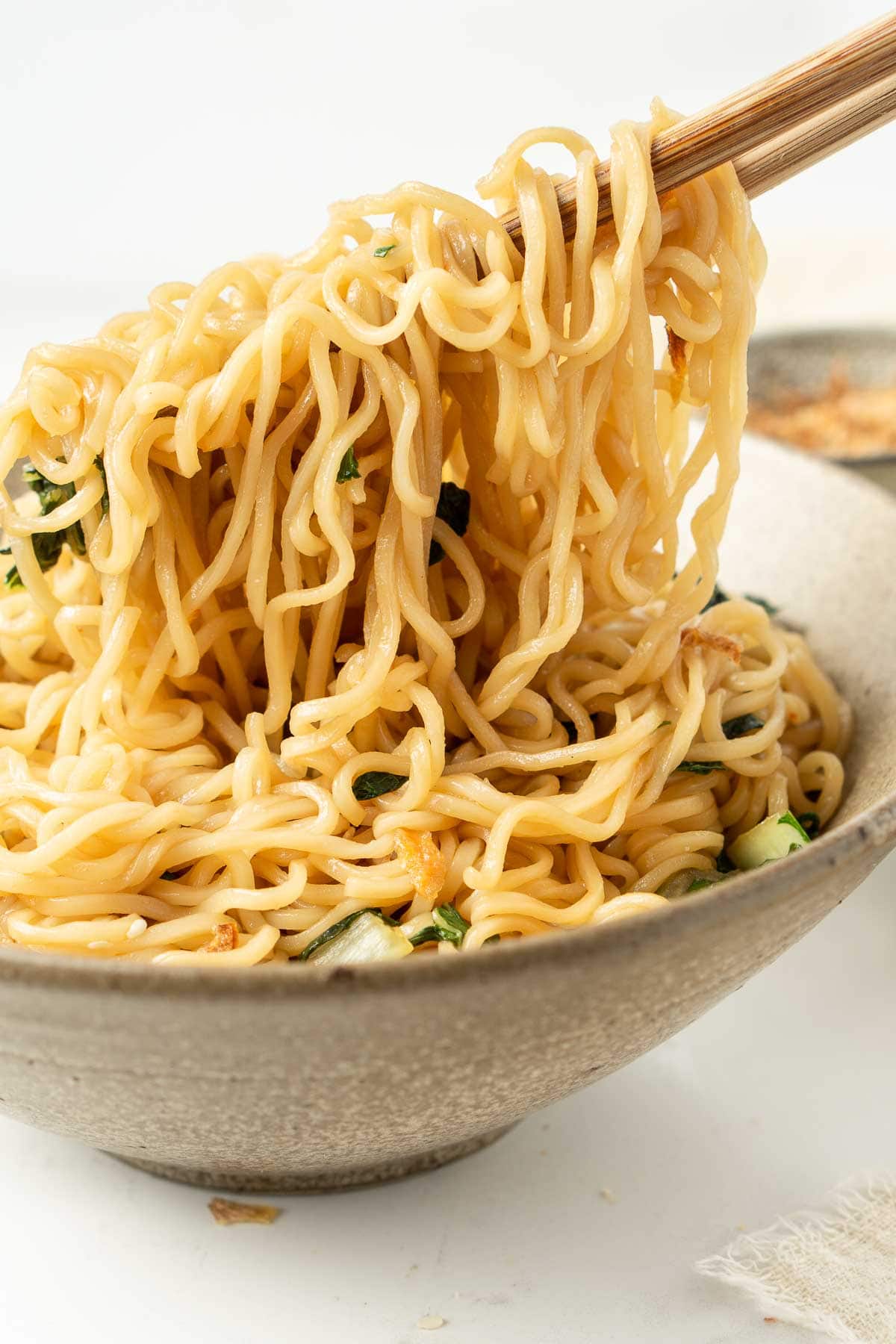 Close up of bowl of noodles with chopsticks. 