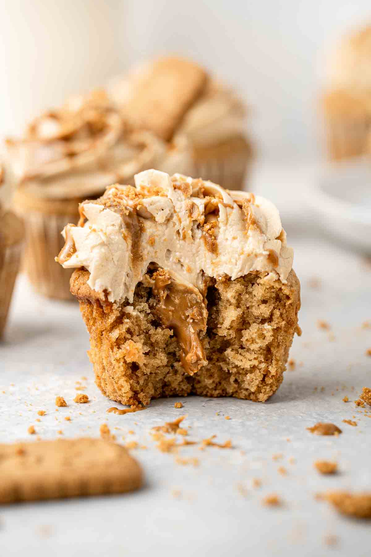 A cupcake with a bite taken revealing the biscoff centre.