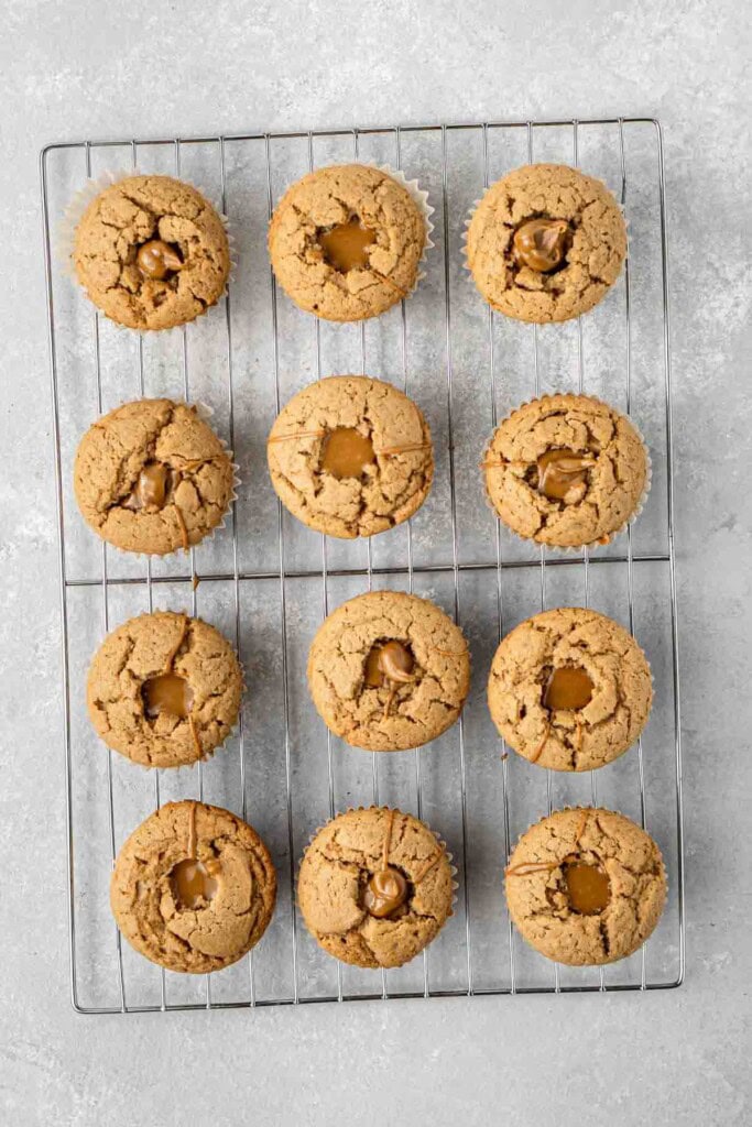 Biscoff filled cupcakes on a wire rack.