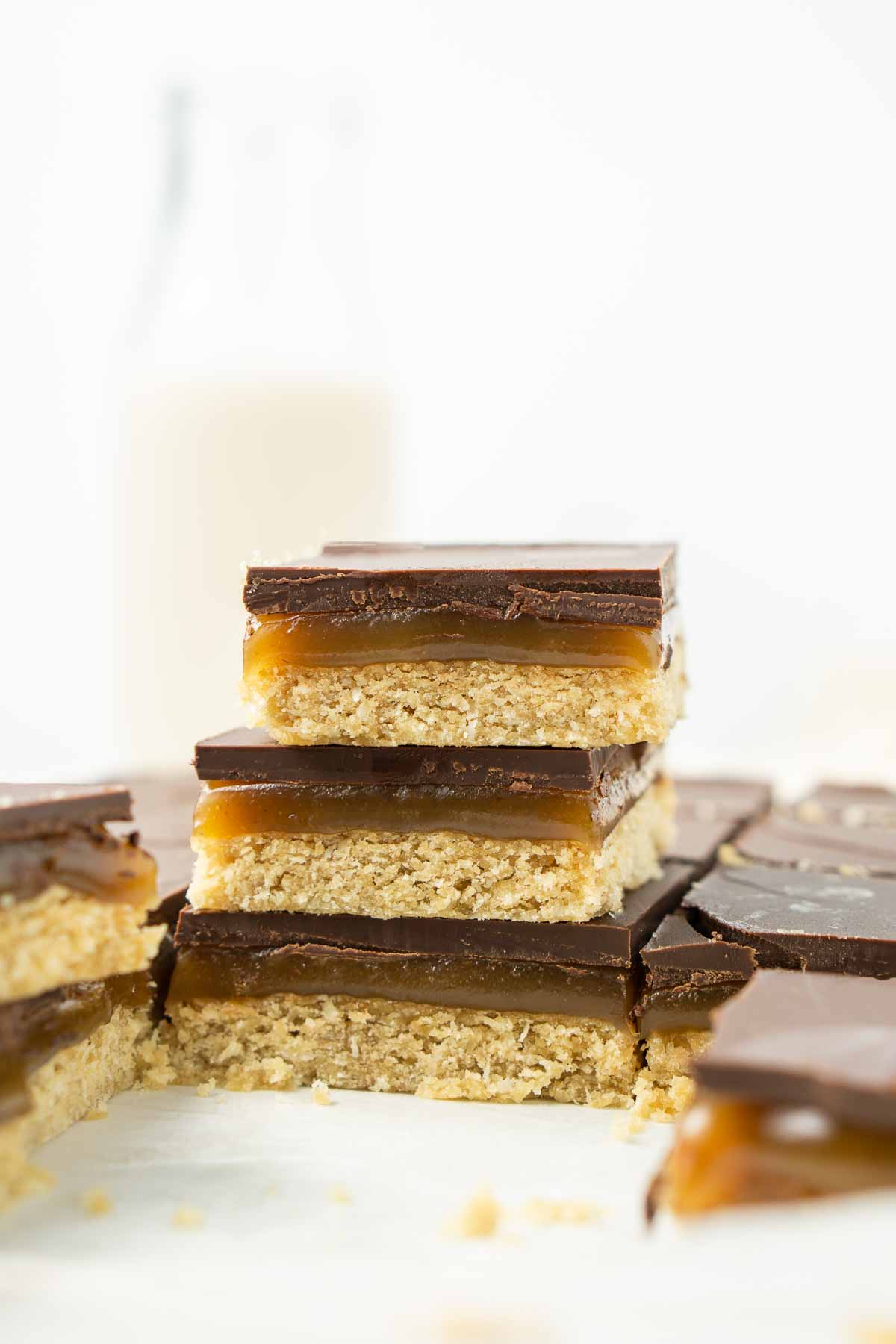 Close up of three pieces of vegan caramel slice staked up.